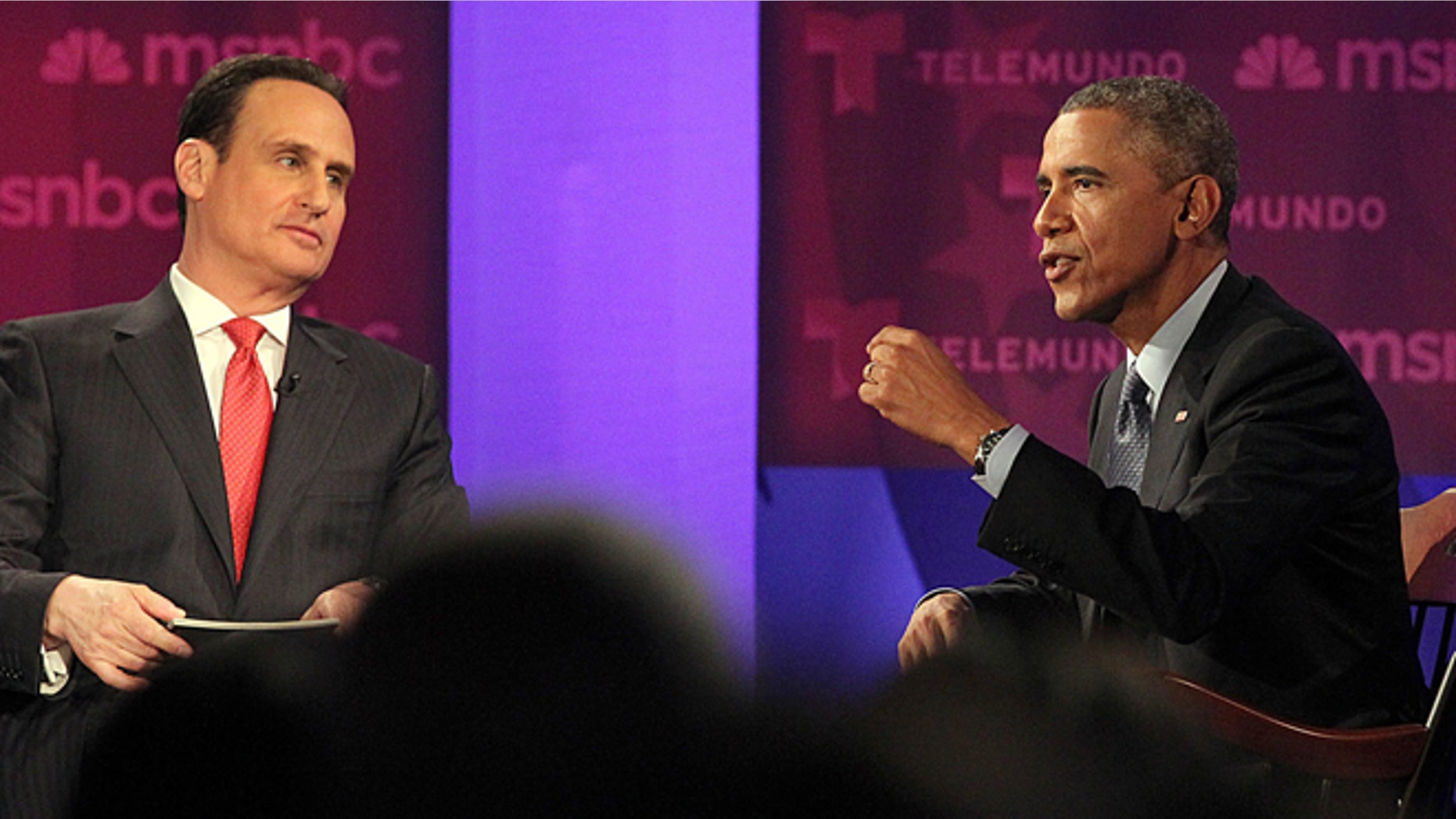 President Barack Obama, right, gestures during a town hall meeting on immigration with Jose Diaz-Balart, hosted by Telemundo and MSNBC, Wednesday, Feb. 25, 2015, at Florida International University in Miami. (AP Photo/El Nuevo Herald, Pedro Portal, Pool)