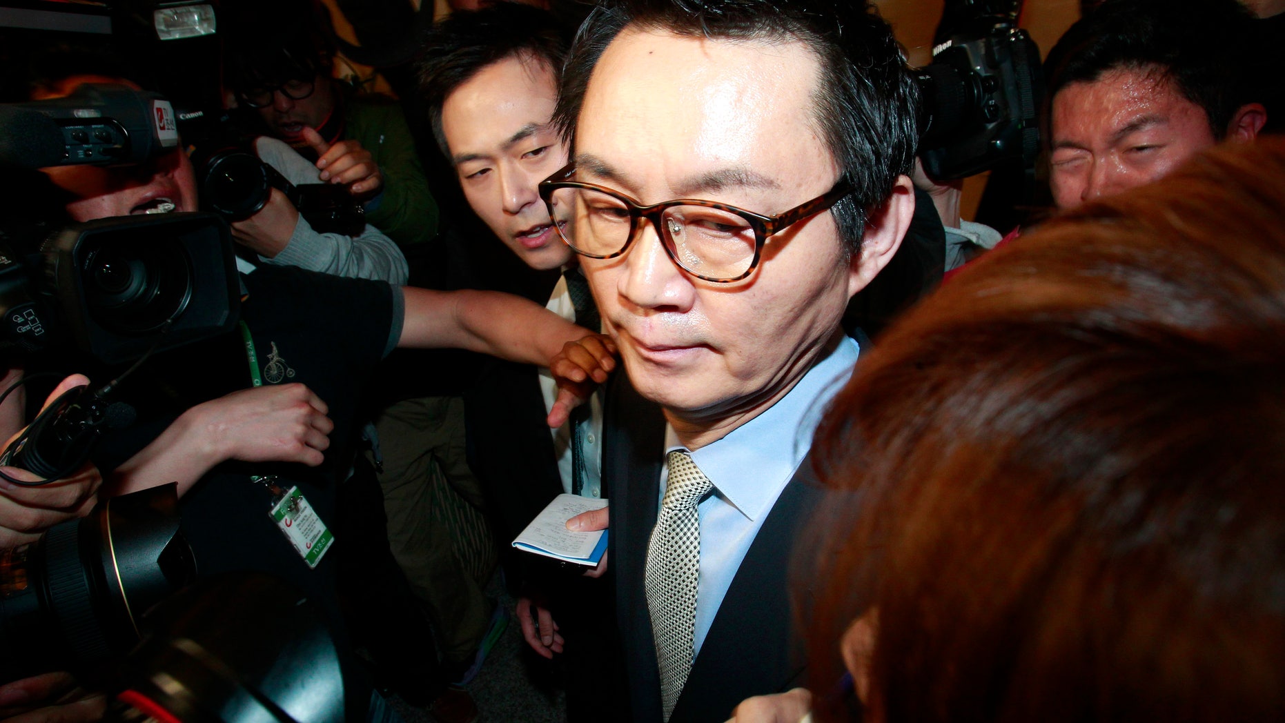 South Korean President Park Geun-hye's spokesman Yoon Chang-jung surrounded by journalists leaves after a press conference in Seoul, South Korea, Saturday, May 11, 2013. Park fired Yoon because of what her office said Friday was a “disgraceful incident” during Park’s trip to the United States, in what could be a domestic blow after an otherwise widely praised appearance in Washington. Without elaborating, the presidential Blue House said on its website that unspecified actions by Yoon marred the government’s dignity. (AP Photo/Ahn Young-joon)