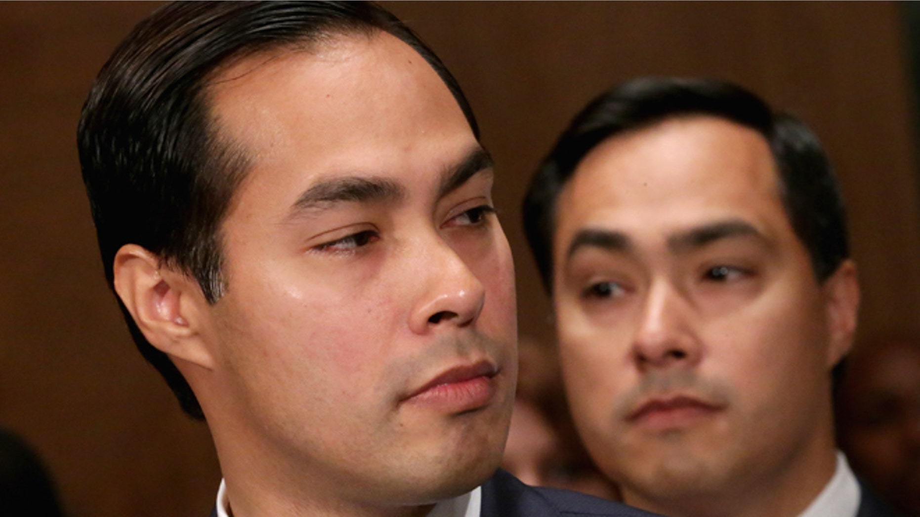 WASHINGTON, DC - JUNE 17: Mayor Julian Castro (L) testifies during his confirmation hearing before the Senate Banking, Housing and Urban Affairs Committee with his twin brother, Rep. Joaquin Castro (D-TX), in the background June 17, 2014 in Washington, DC. The current mayor of San Antonio, Texas, Castro has not faced serious opposition in the Senate. (Photo by Chip Somodevilla/Getty Images)