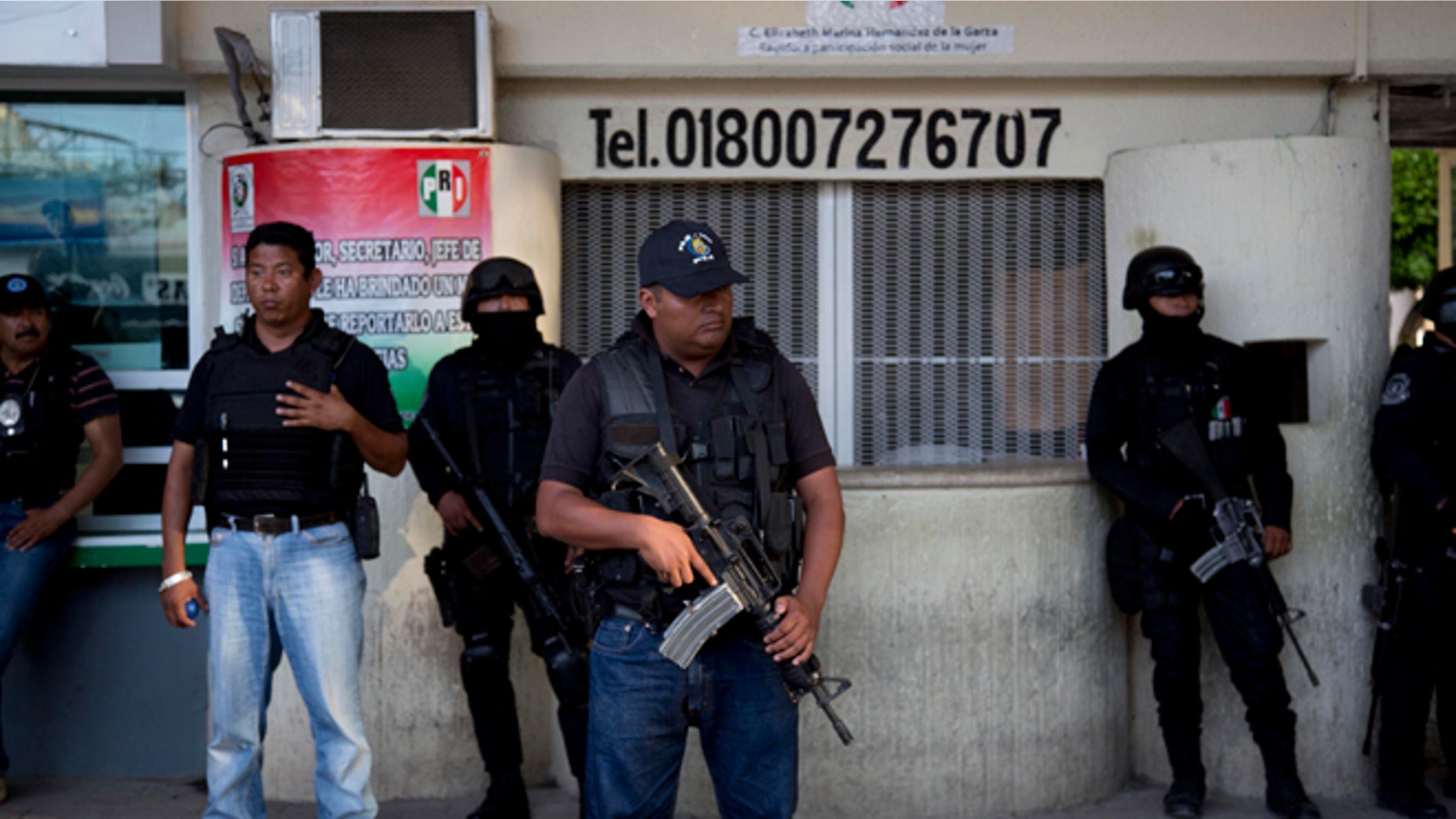 Police officers stand guard outside the municipality of Iguala, Mexico, Monday, Oct. 6, 2014. Federal officials on Monday disarmed local police and took over security after an attack on students that left at least six dead and 43 missing. Officials say that police officers were in league with a local gang called the Guerreros Unidos in carrying out the attack, and sent a new preventative unit of the federal police to keep order and help look for the missing. (AP Photo/Eduardo Verdugo)