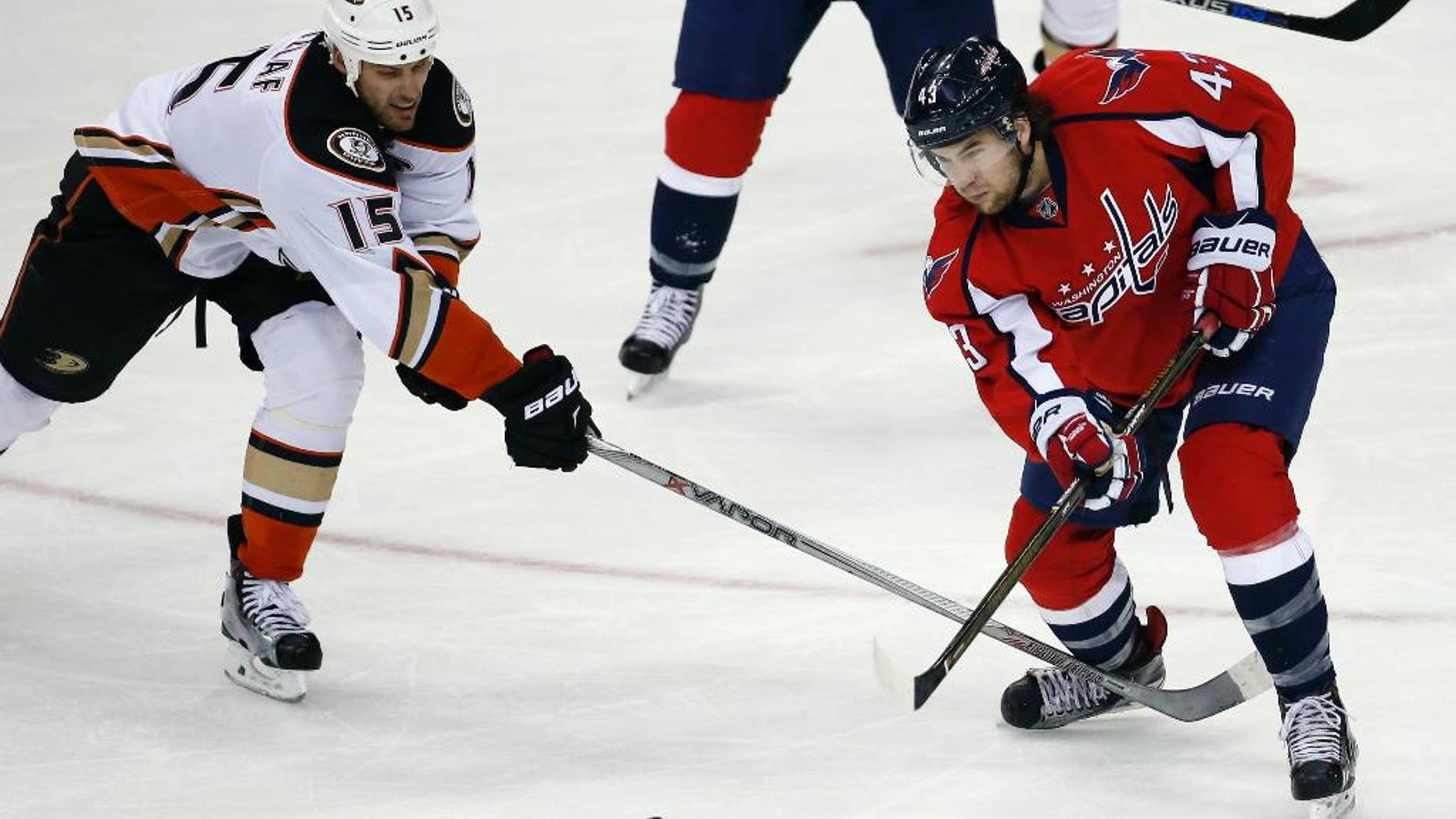 FILE - In this April 10, 2016 file photo, Washington Capitals right wing Tom Wilson (43) passes the puck as Anaheim Ducks center Ryan Getzlaf (15) defends during an NHL hockey game in Washington. Wilson’s knee-on-knee hit on Pittsburgh’s Conor Sheary cost him $2,404 in the form of a fine from the NHL, but the Washington Capitals forward escaped a suspension that could have altered the second-round playoff series against the Penguins. (AP Photo/Alex Brandon, File)