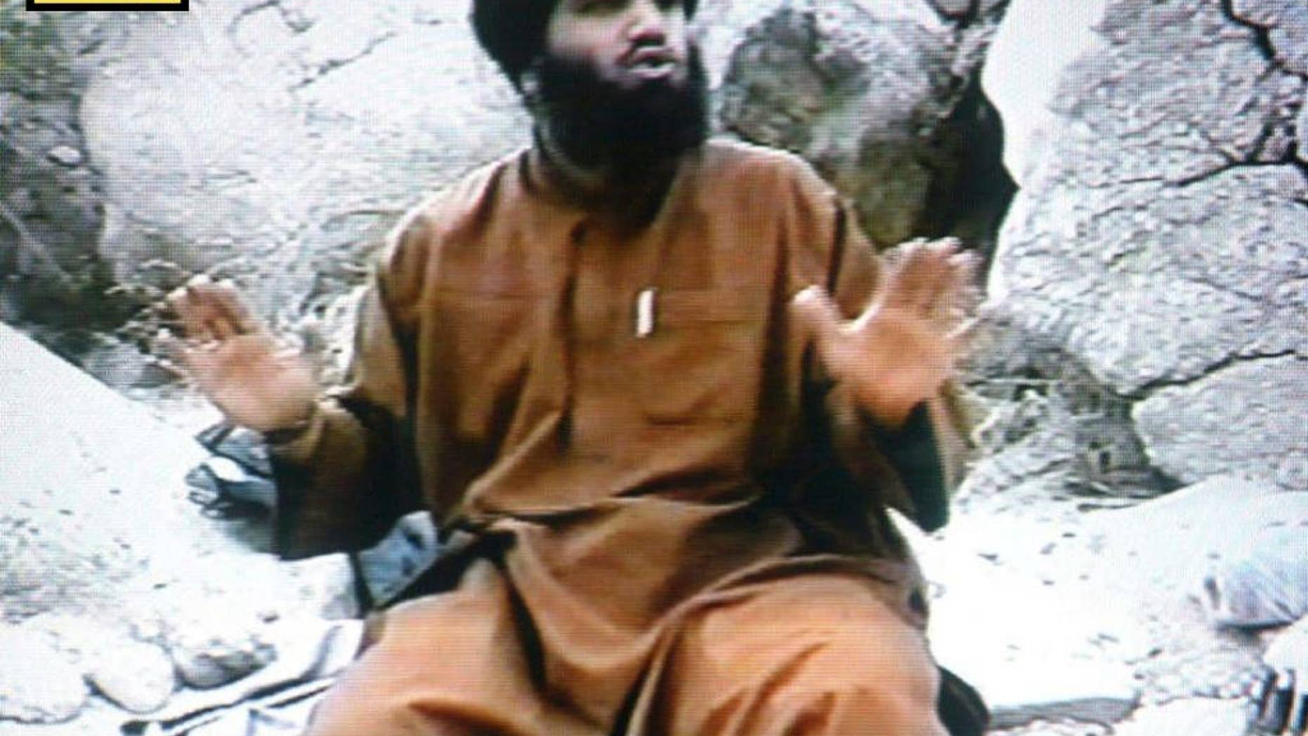 In this undated Photo taken from video and provided by the United States Attorney’s Office for the Southern District of New York, defendant Suliman Abu Ghayth, sits on the ground somewhere in Afghanistan. Abu Ghayth, is being tried in New York for plotting to kill Americans by being a motivational speaker at al-Qaida training camps before the Sept. 11 attacks and for serving as a spokesman for the terror group afterward. This photo was among the trial exhibits that the federal prosecutor showed the jury, sometimes repeatedly. (AP Photo/US Attorney’s Office for the Southern District of New York)