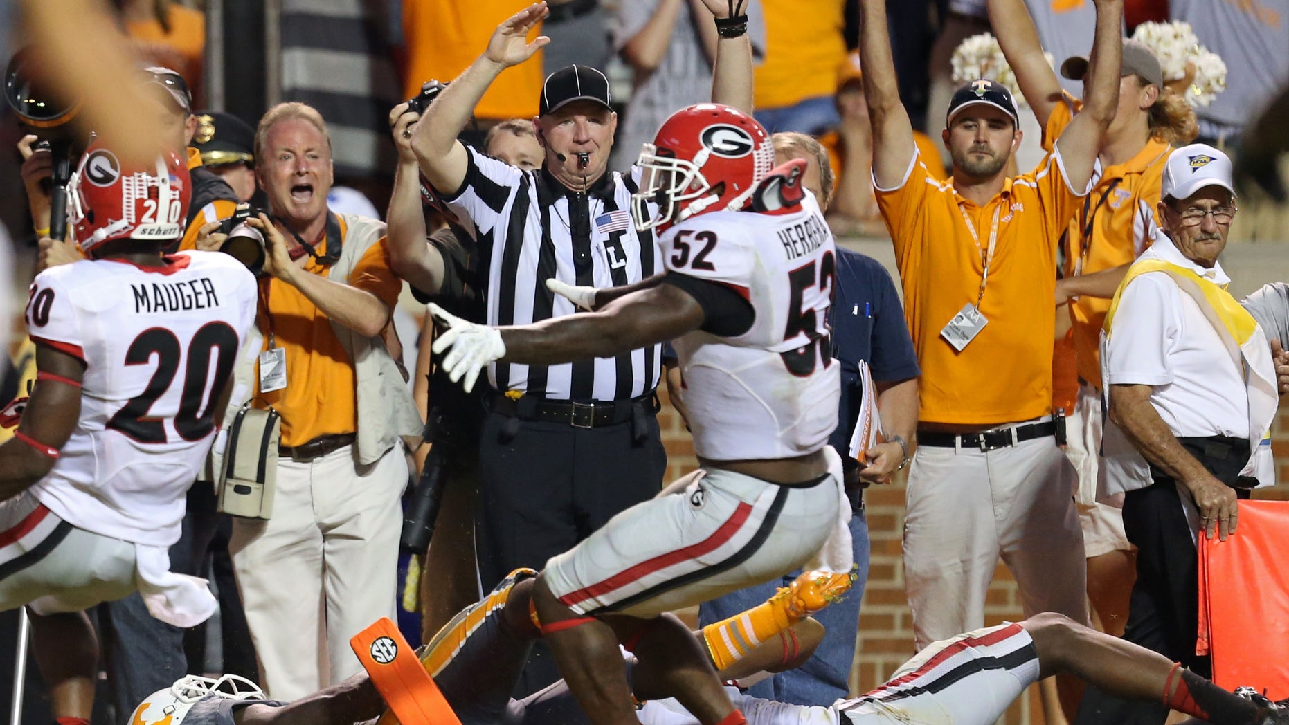 Tennessee's Alton Howard, bottom left, falls into the endzone after he fumbled the ball for a turnover as Georgia's Amarlo Herrera (52) contents the original call as a touchdown in overtime of an NCAA college football game in Knoxville, Tenn., Oct. 5, 2013. (AP Photo/Atlanta Journal-Constitution, Jason Getz)