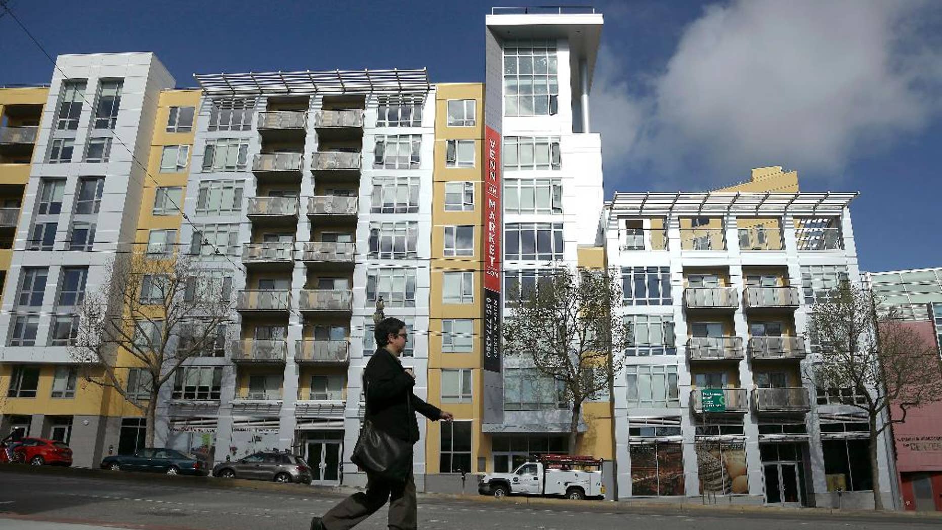 FILE - In this Monday, March 17, 2014, file photo, a woman walks across the street from the Venn on Market apartment and condominium building in San Francisco. U.S. home prices rose at a steady pace in March, pushed higher by a limited supply of houses for sale, according to the Standard & Poor's/Case-Shiller 20-city home price index released Tuesday, May 26, 2015. (AP Photo/Jeff Chiu, File)