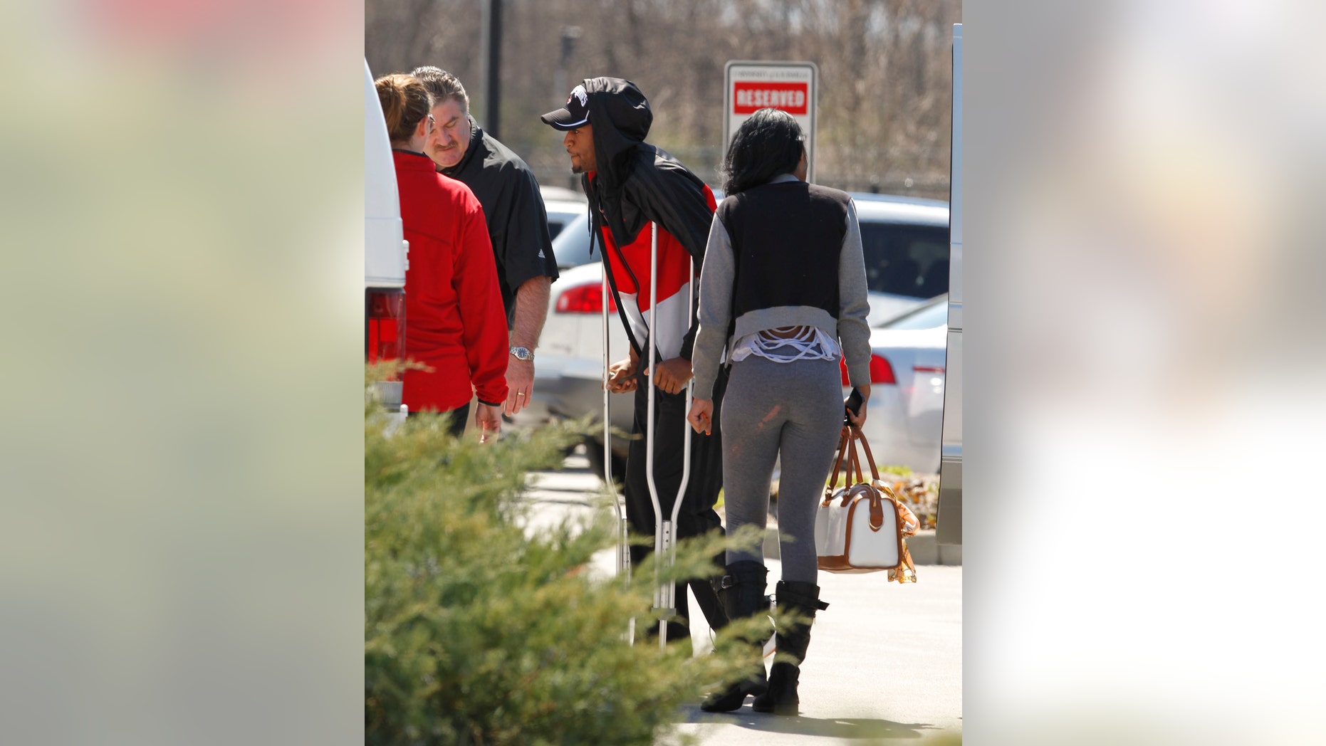 Louisville basketball player Kevin Ware, center, walks to the back doors of the Yum! Center to be reunited with his teammates, Tuesday, April 2, 2013, in Louisville, Ky. Ware was back on campus Tuesday afternoon after he had been released from an Indianapolis hospital, two days after breaking his right leg during the Cardinals' Final Four-clinching victory. (AP Photo/The Courier-Journal, John Sommers II) NO SALES; MAGS OUT; NO ARCHIVE; MANDATORY CREDIT