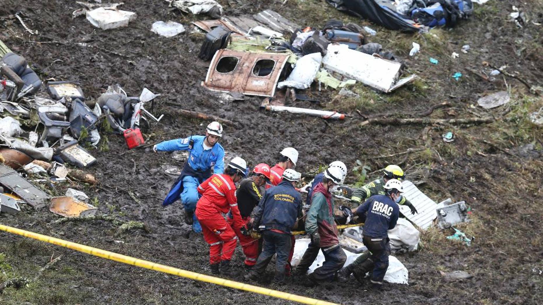 FILE - In this Nov. 29, 2016, file photo, rescue workers recover a body from the wreckage site of an airplane crash, in La Union, a mountainous area near Medellin, Colombia. The chartered plane was carrying a Brazilian soccer team to the biggest match of its history when it crashed into a Colombian hillside and broke into pieces. The Bolivian aviation official who signed off the flight plan of the chartered aircraft is breaking her silence in a public letter published on Thursday, Dec. 8, accusing her bosses of trying to stage a cover-up. (AP Photo/Fernando Vergara, File)