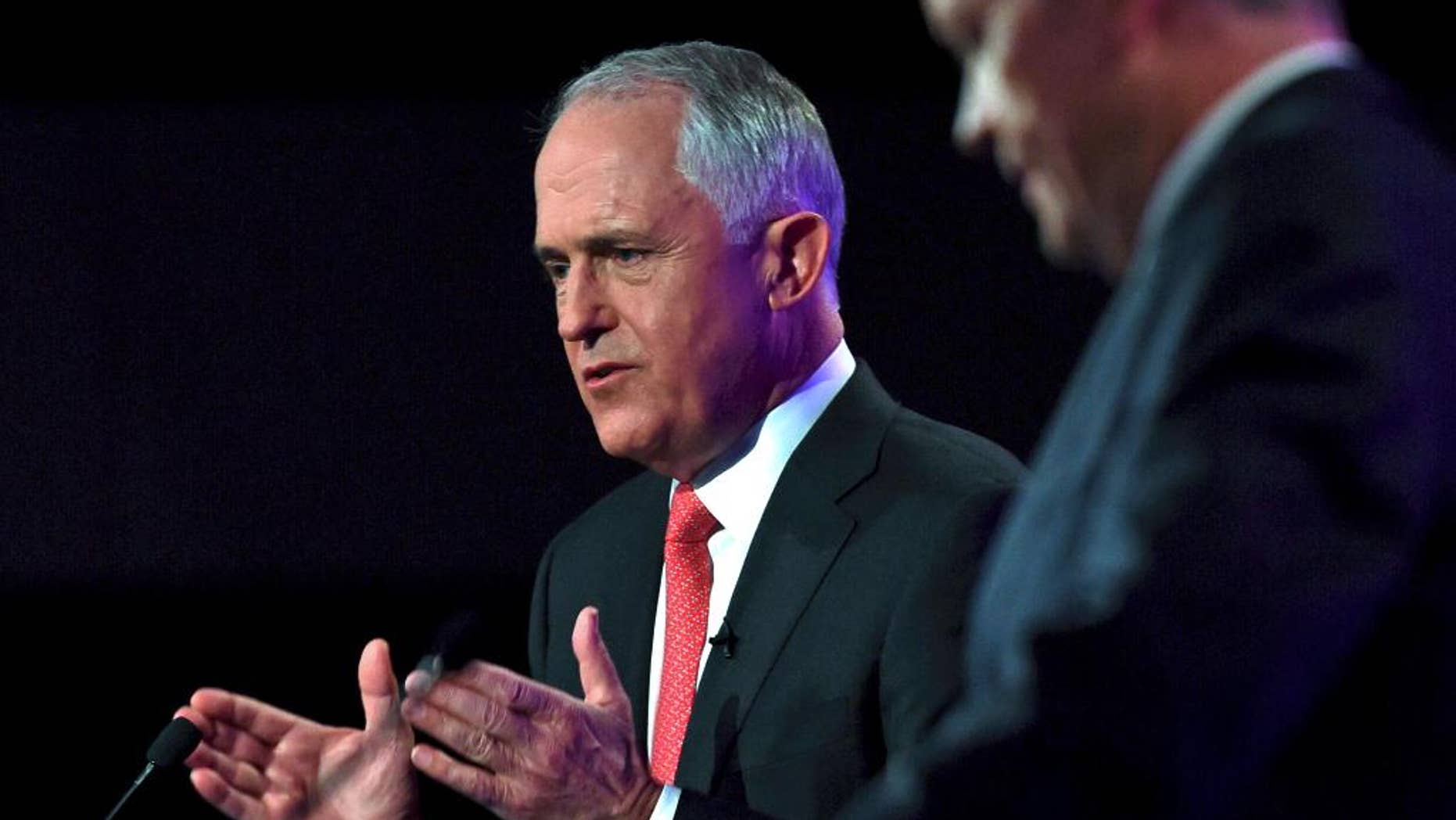 In this May 29, 2016, file photo, Australian Prime Minister Malcolm Turnbull, left, speaks as opposition leader Bill Shorten listens at a leaders' debate at the National Press Club in Canberra. Opinion polls suggest the conservative coalition government remains neck-and-neck with the center-left Labor Party opposition since the July 2, 2016 election was officially called early in May, despite efforts by both sides to break out with a range of policy announcements. (AP Photo/Tracey Nearmy/Pool, File)
