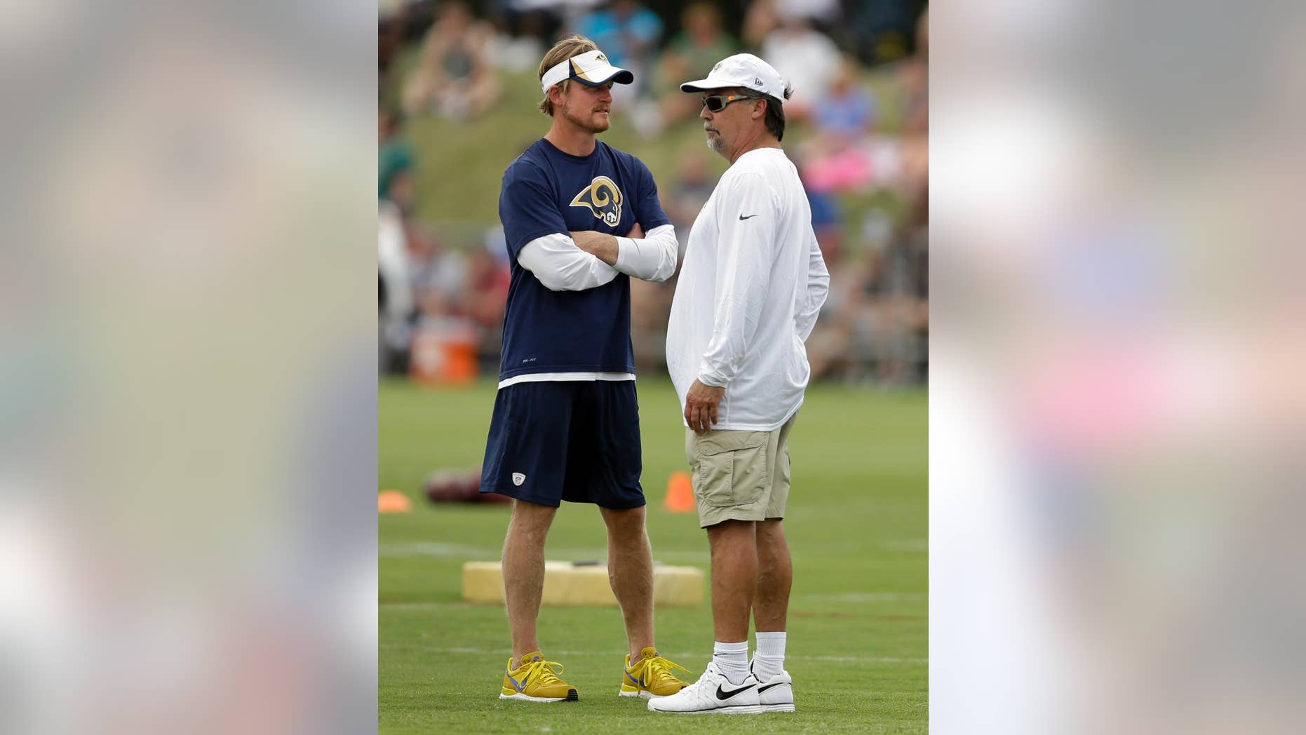 St. Louis Rams head coach Jeff Fisher, right, talks with Rams general manager Les Snead during training camp at the NFL football team's practice facility on Saturday, July 26, 2014, in St. Louis. (AP Photo/Jeff Roberson)