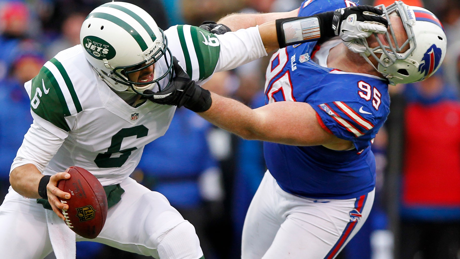 New York Jets quarterback Mark Sanchez (6) holds off Buffalo Bills defensive tackle Kyle Williams (95) during the second half of an NFL football game on Sunday, Dec. 30, 2012, in Orchard Park, N.Y. Buffalo won 28-9. (AP Photo/Bill Wippert)