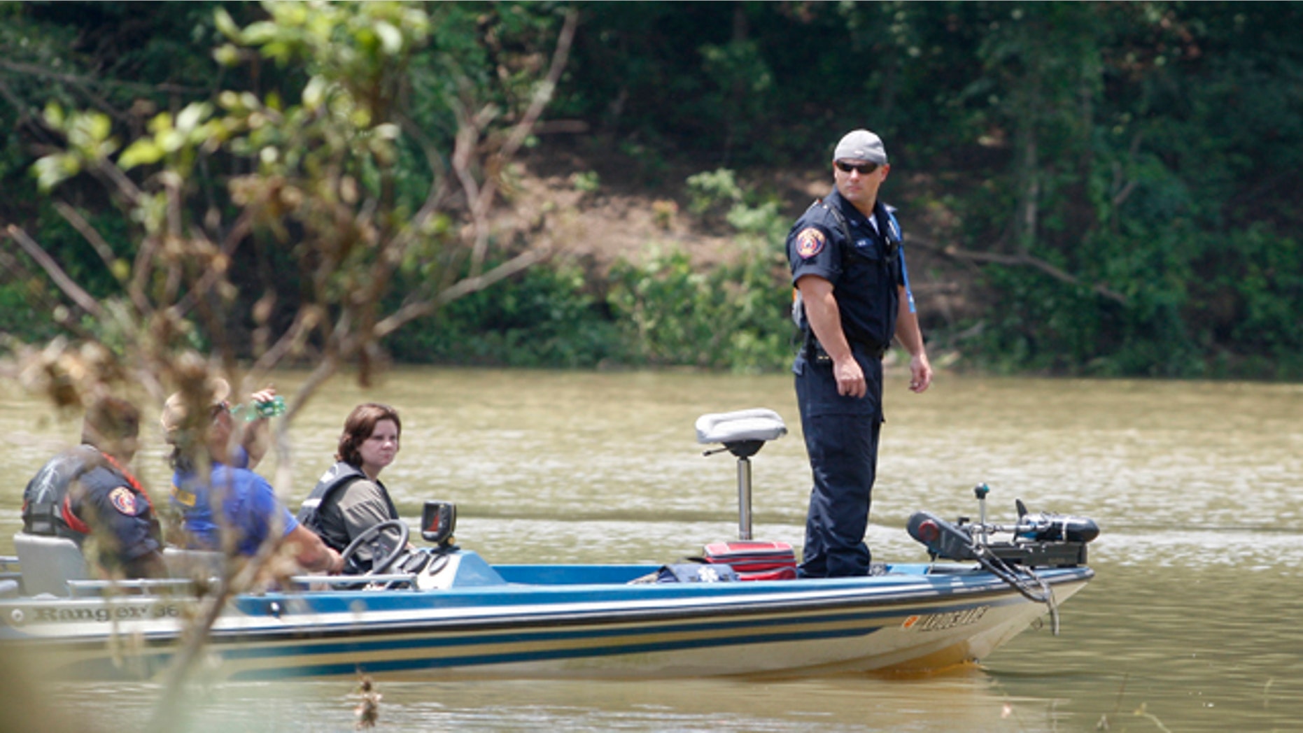 June 12: Officer Les Munn, of Texarkana, Ark., stands at the front of a boat as officials search near the edge of the Little Missouri River near Langley, Ark.