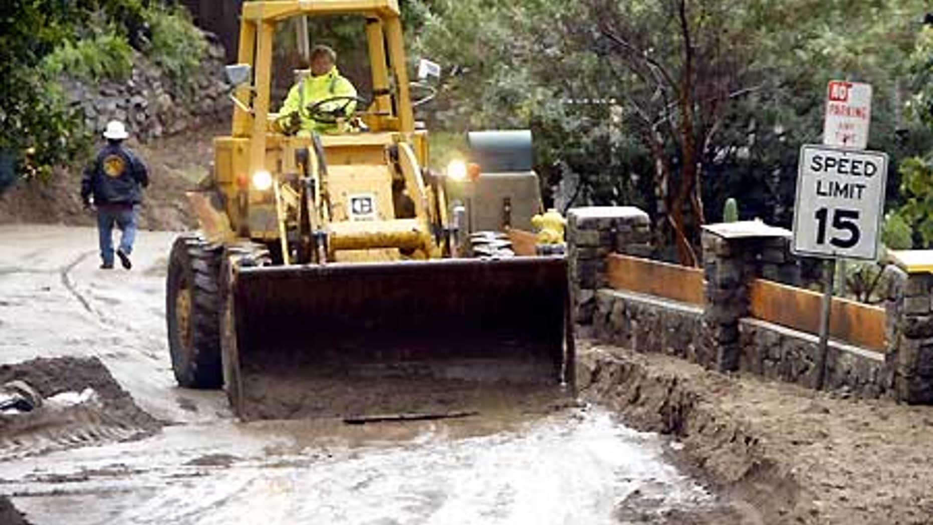 Feb. 7: Heavy equipment removes mudflow on Woodland Drive in Sierra Madre, Calif.