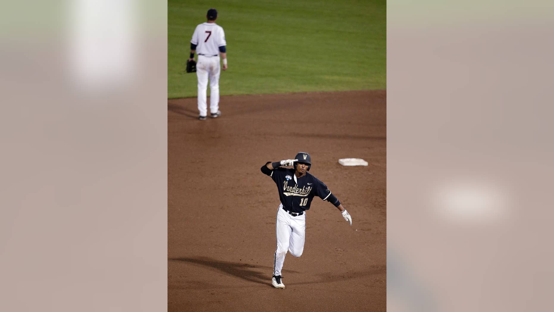 Vanderbilt's John Norwood celebrates as he runs the bases after hitting a home run against Virginia in the eighth inning of Game 3 of the best-of-three NCAA baseball College World Series finals in Omaha, Neb., Wednesday, June 25, 2014. (AP Photo/Nati Harnik)