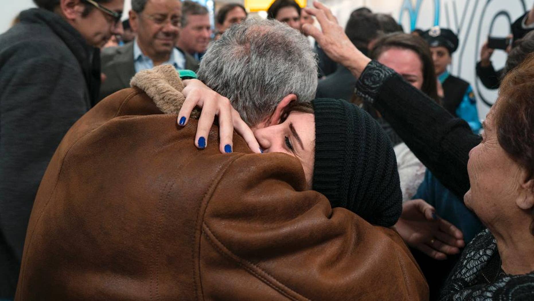 FILE - In a Monday, Feb. 6, 2017 file photo, family members who have just arrived from Syria embrace and are greeted by family who live in the United States upon their arrival at John F. Kennedy International Airport in New York. Organizers in cities across the U.S. are telling immigrants to miss class, miss work and not shop on Thursday, Feb. 16, 2017, as a way to show the country how important they are to America's economy and way of life. "A Day Without Immigrants" actions are planned in cities including Philadelphia, Washington, Boston and Austin, Texas. (AP Photo/Craig Ruttle)