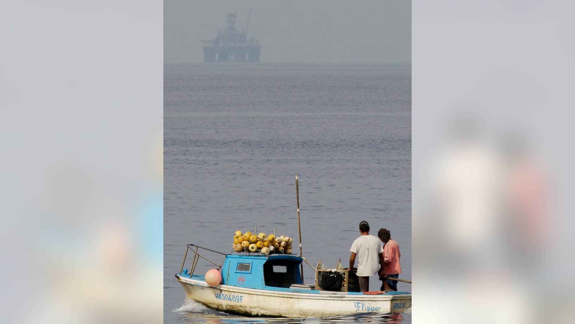 FILE - In this Jan. 8, 2012 file photo, an oil rig floats in the distance as fishermen work in Havana Bay, Cuba. Cuba and the United States signed an accord on Monday, Jan. 9, 2017 on preventing and cleaning up oil spills in the Gulf of Mexico and the Florida Straits. (AP Photo/Javier Galeano, File)