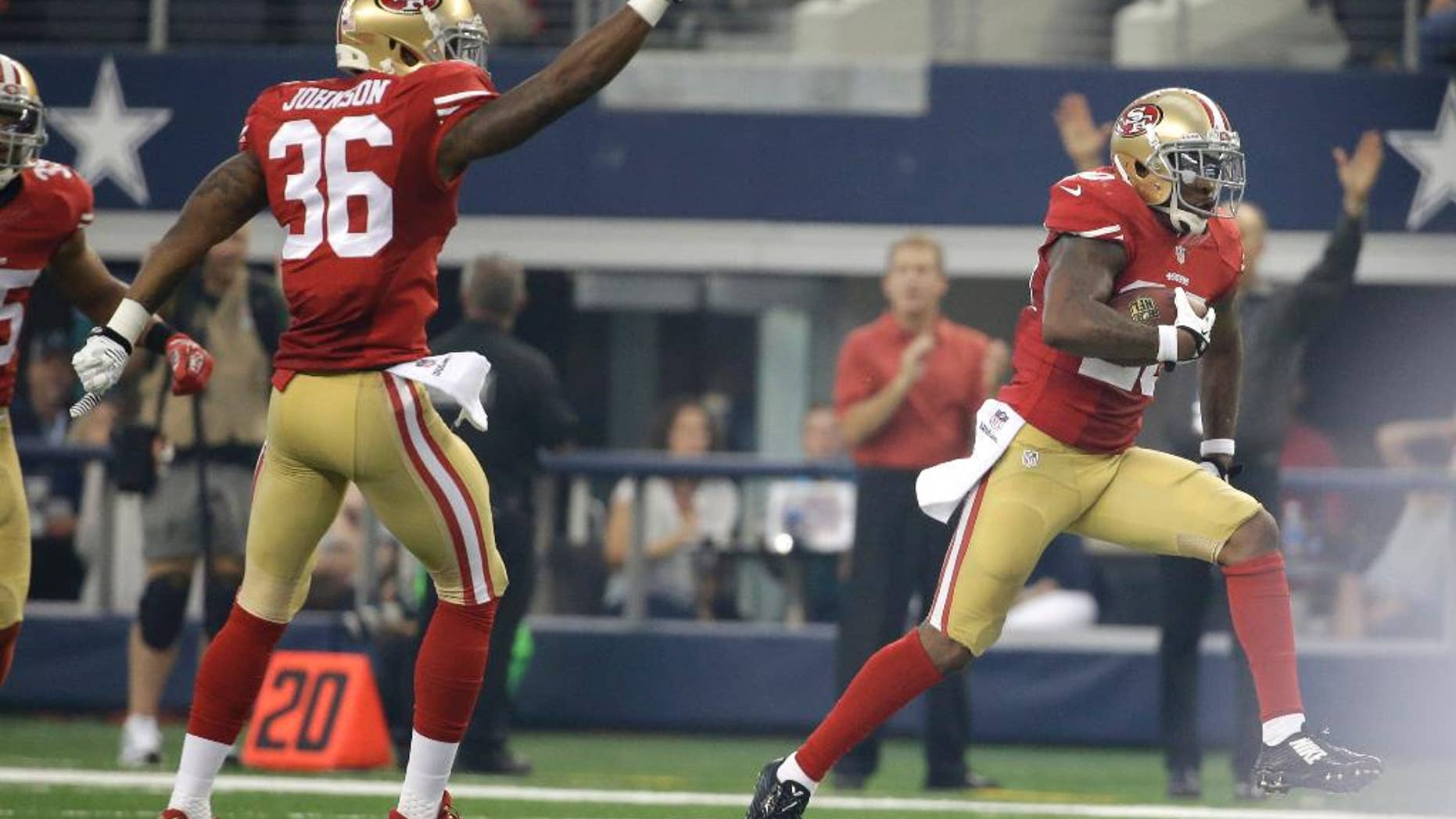 San Francisco Dontae Johnson (36) gestures as teammate defensive back Perrish Cox (20) runs back an interception against the Dallas Cowboys in the first half of an NFL football game, Sunday, Sept. 7, 2014, in Arlington, Texas. (AP Photo/Tony Gutierrez)