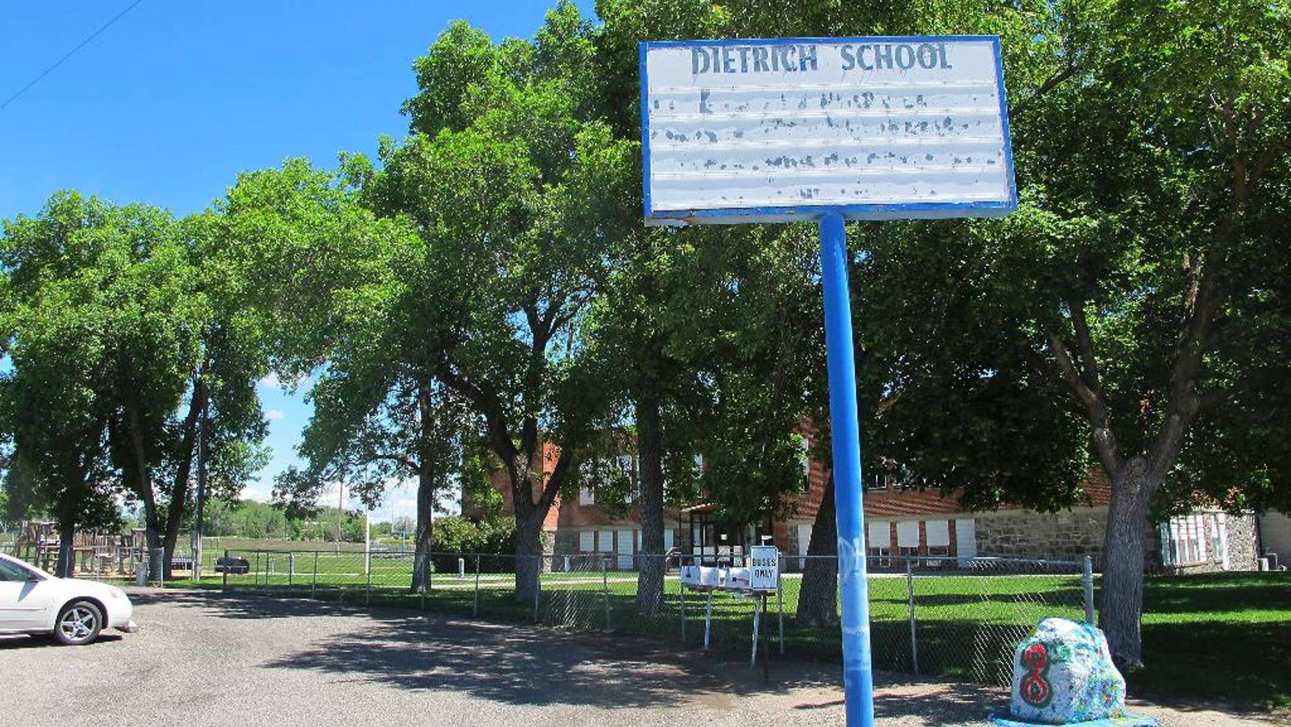 FILE - In this May 26, 2016, file photo, an empty school reader board stands in front of the only school building in Dietrich, Idaho. The small community is struggling with the national attention brought by reports that a disabled black football player was raped by his white high school teammates. The allegations of racist taunts and physical abuse suffered by the teen were revealed this month when the family filed a $10 million lawsuit against the Dietrich School District. (AP Photo/Kimberlee Kruesi, File)