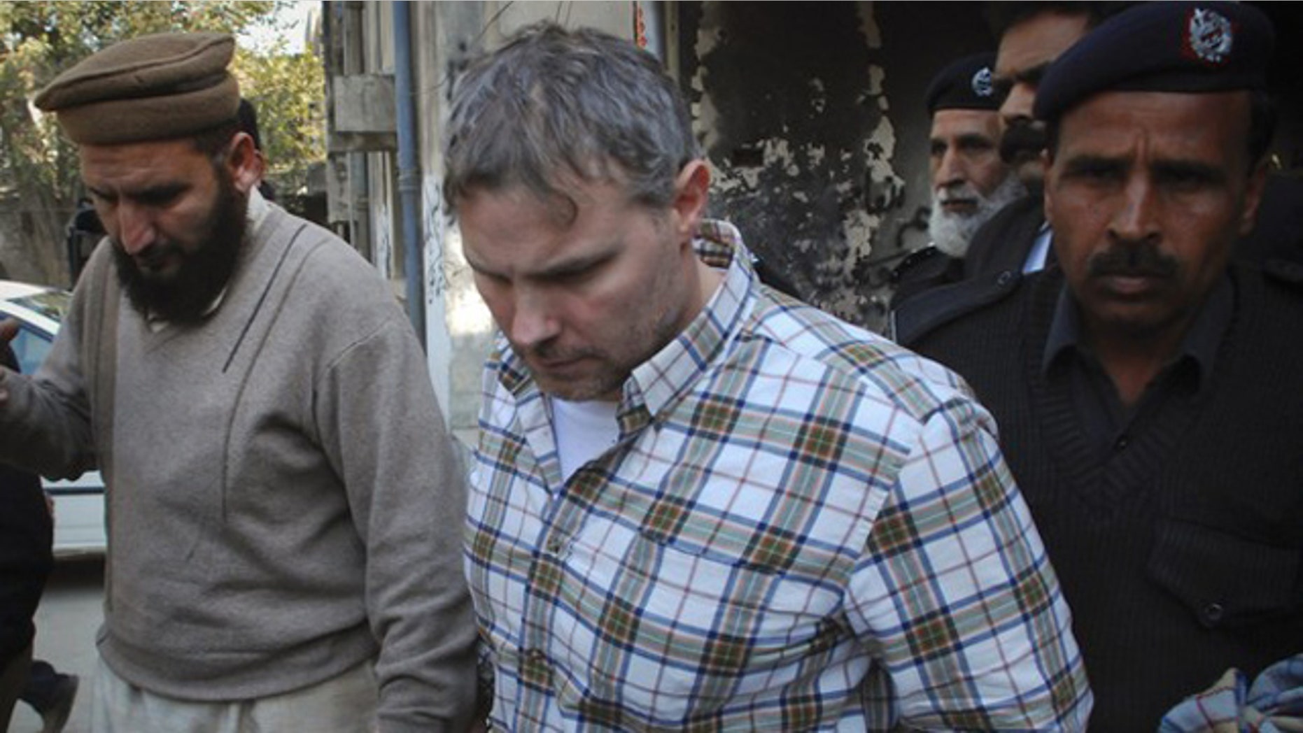 Jan. 28: A U.S. consulate employee is escorted by police and officials out of court after facing a judge in Lahore.