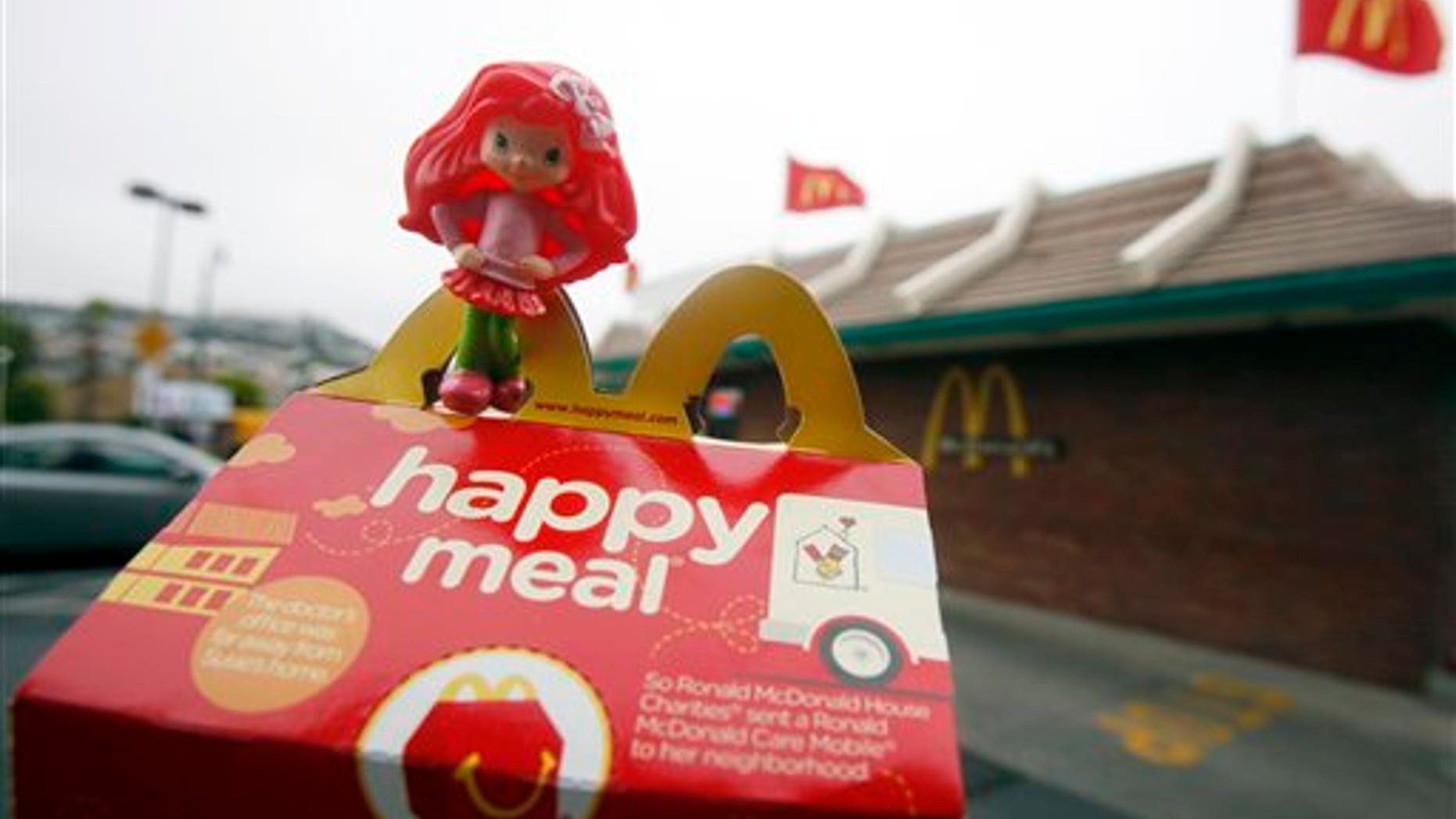 FILE - In this Oct. 1, 2010 file photo, a Happy Meal box and toy are shown outside of a McDonald's restaurant in San Francisco. City lawmakers on Tuesday, Nov. 2, 2010, approved legislation that they hope will force fast-food chains such as McDonald's to make their children's meals healthier or stop selling them with toys. (AP Photo/Jeff Chiu, File)