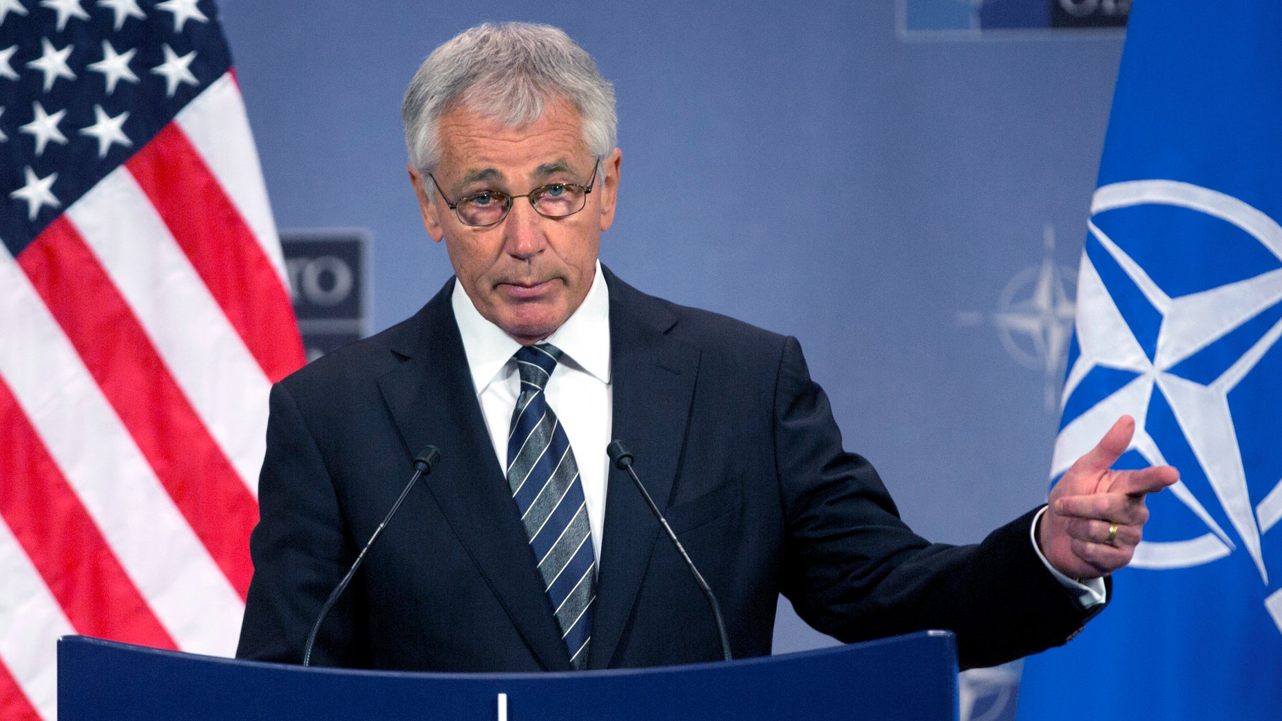 FILE - In this Oct. 23, 2013 file photo, Secretary of Defense Chuck Hagel speaks during a media conference after a meeting of NATO defense ministers at NATO headquarters in Brussels. Defense Secretary Chuck Hagel on Thursday, Oct. 31, 2013 sharply criticized U.S. states that are defying the Pentagon by refusing to allow National Guard facilities to issue ID cards that enable same-sex spouses of military members to claim benefits. (AP Photo/Virginia Mayo, File)