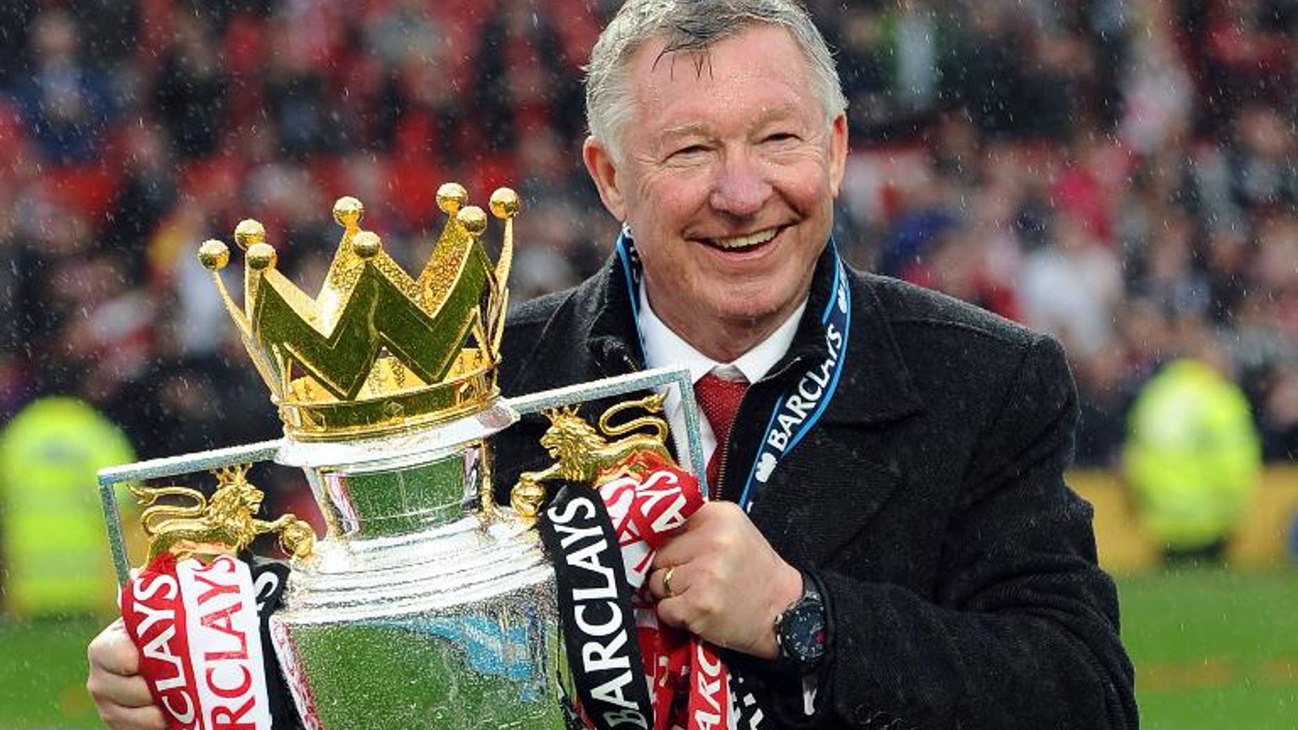 Then Manchester United manager Alex Ferguson holds the Premier League trophy after a match against Swansea City at Old Trafford in Manchester on May 12, 2013