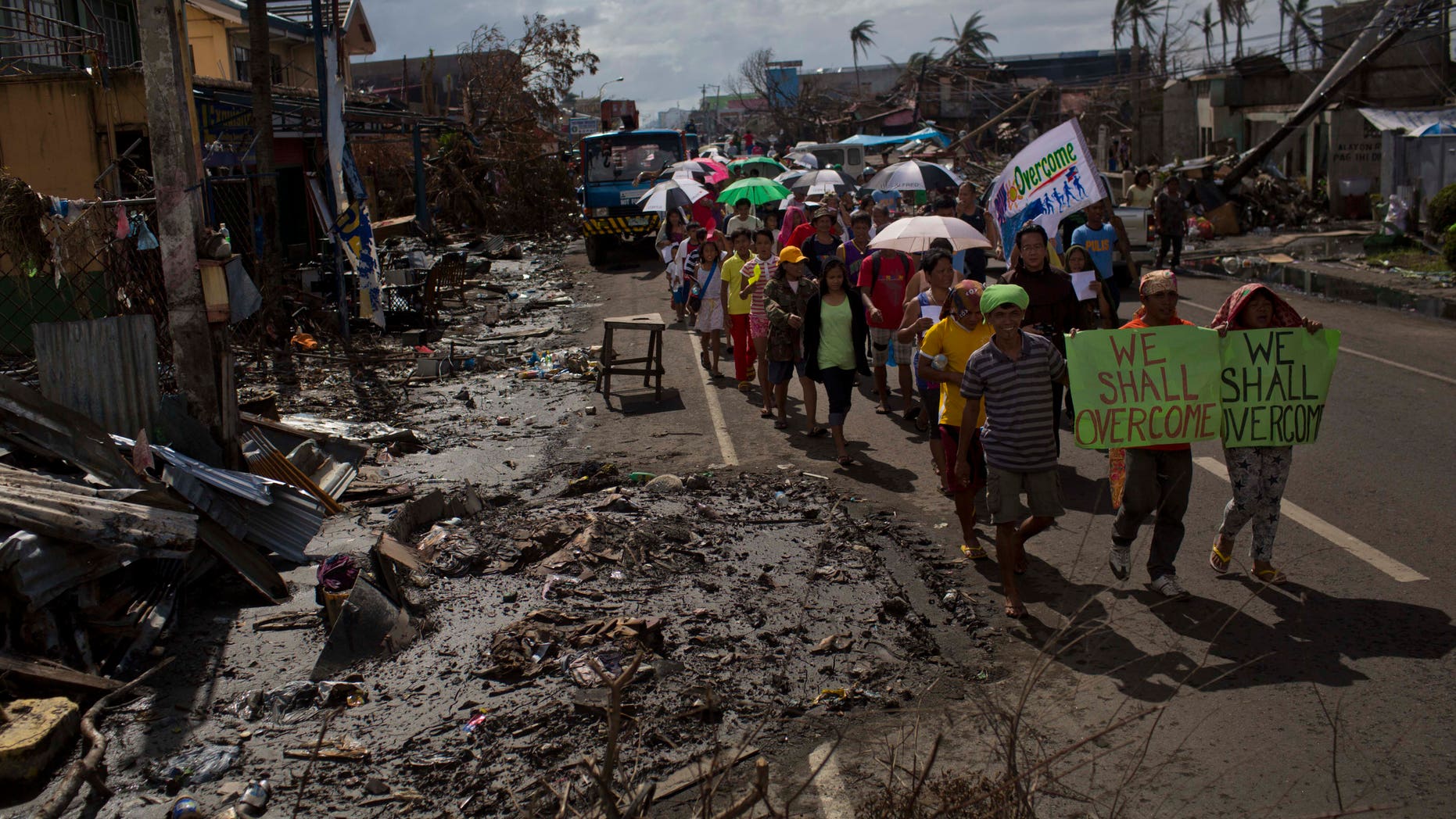 People march in the rain Tacloban, Philippines during a procession to call for courage and resilience among their Typhoon Haiyan survivors on Tuesday Nov. 19, 2013. In the wake of every major global catastrophe, the world’s media dutifully broadcasts the traditional narrative of grief and despair. Stories of loss and desperation were ubiquitous in Haiyan as well, and rightly so: more than 4,000 people were killed in the storm’s first few hours, and blackened bodies with skin peeling are still trapped under the rubble today. But as the crisis eases and aid begins to flow, there is another side to the story that rarely gets beamed out _ people smiling (if only briefly), people joking (if only in passing). (AP Photo/David Guttenfelder)