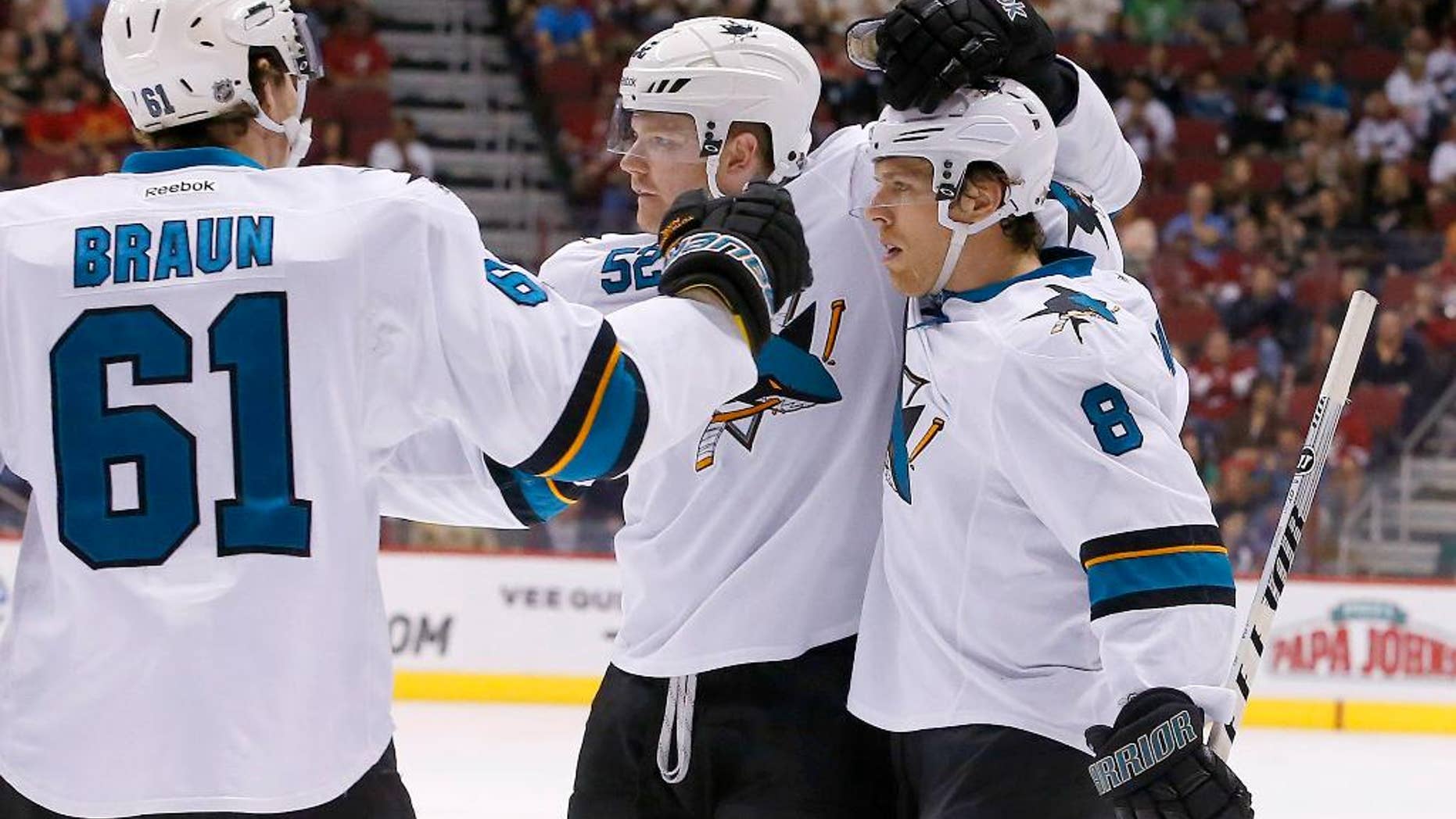 San Jose Sharks' Joe Pavelski (8) celebrates his second goal in the first period of an NHL hockey game against the Phoenix Coyotes with teammates Justin Braun (61) and Matt Irwin (52) on Saturday, April 12, 2014, in Glendale, Ariz. (AP Photo/Ross D. Franklin)