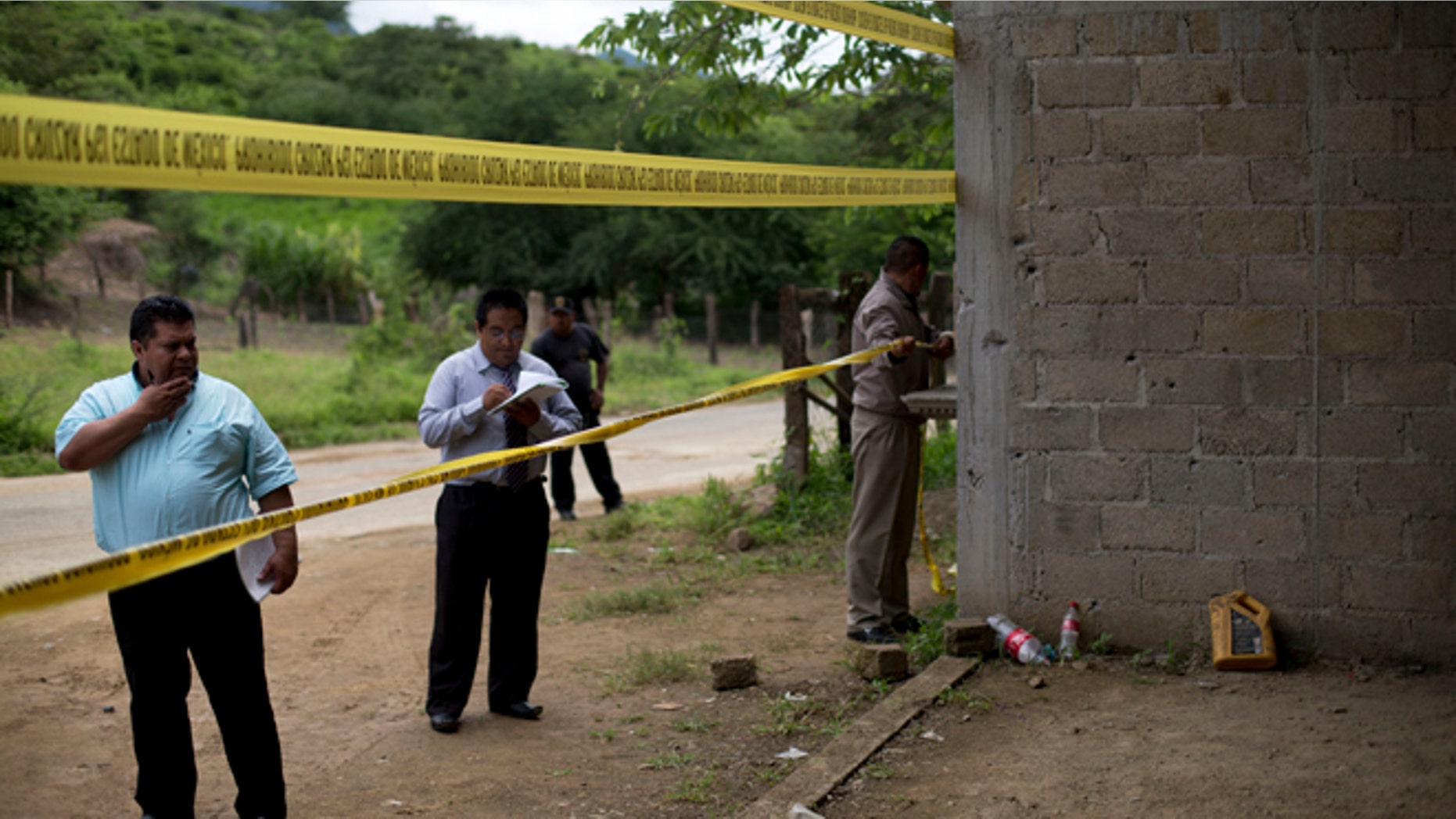 FILE - In this July 3, 2014 file photo, state authorities use crime scene tape to seal off an unfinished warehouse that was the site of a shootout between Mexican soldiers and alleged criminals on the outskirts of the village of San Pedro Limon in Mexico state, Mexico. Three soldiers have been charged with homicide in the June killings of 22 suspected gang members in southern Mexico, Attorney General Jesus Murillo Karam announced on Tuesday Sept. 30 2014. (AP Photo/Rebecca Blackwell, File)