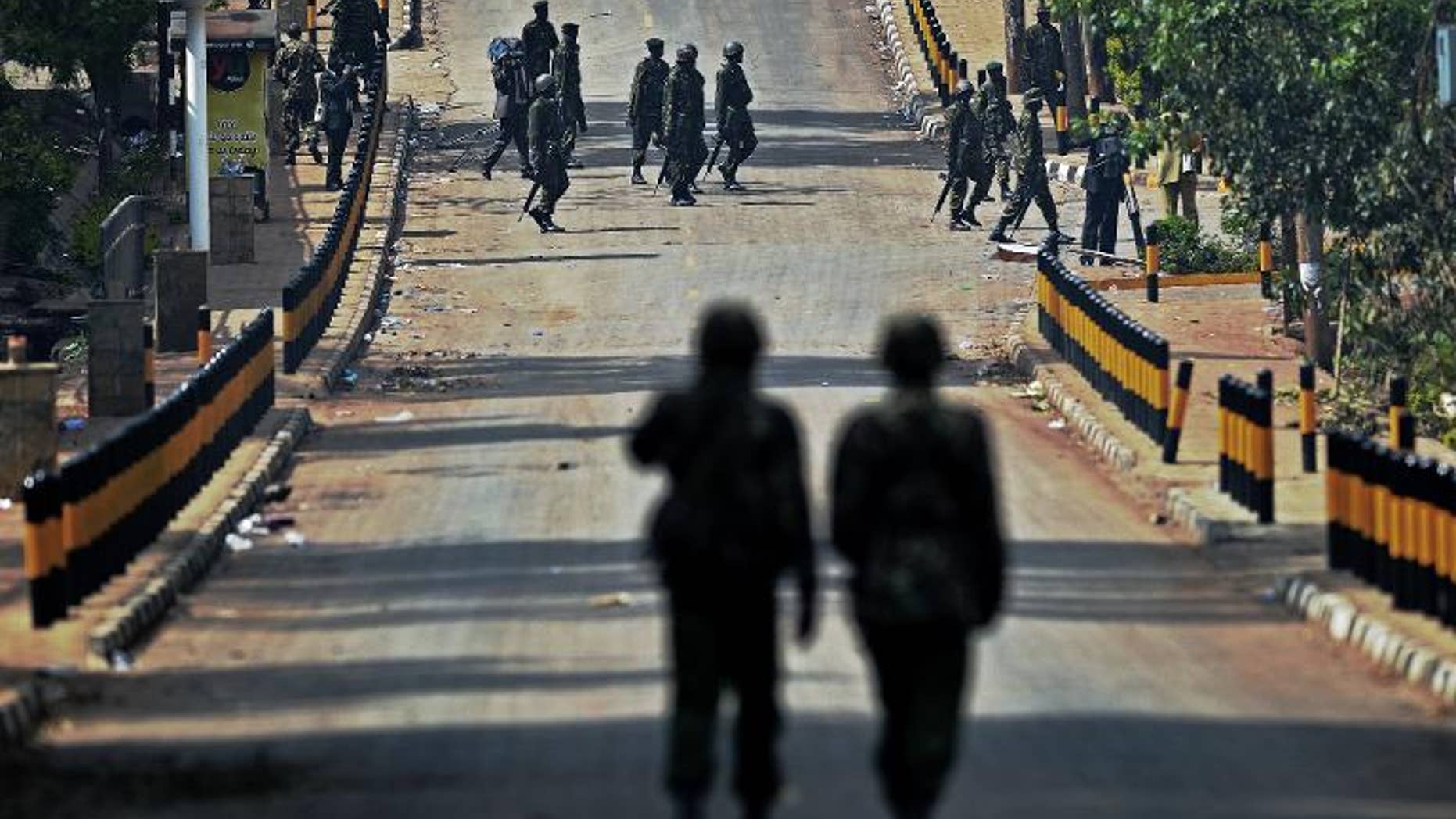 Kenyan soldiers walk along the road outside the Westgate Mall in Nairobi on September 26, 2013