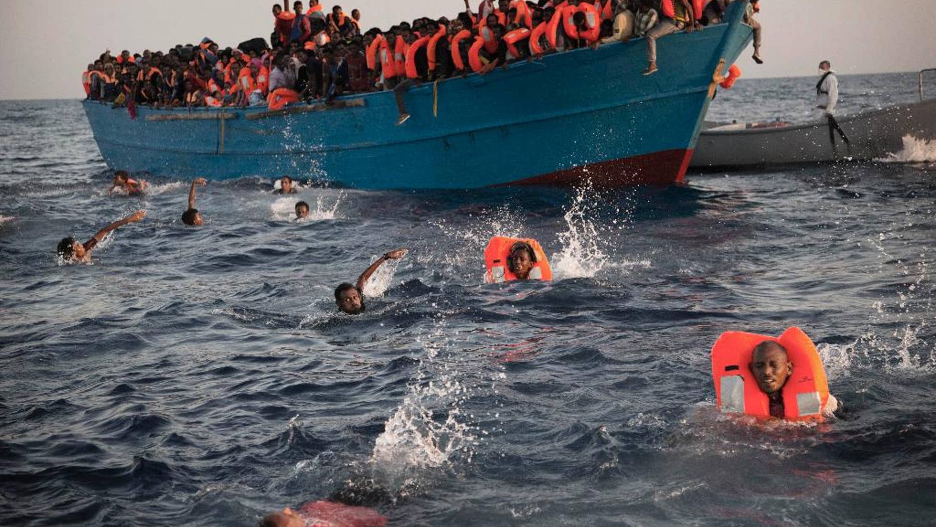 2016 AP YEAR END PHOTOS - Migrants, most from Eritrea, jump into the water from a crowded wooden boat as they are helped by members of an NGO during a rescue operation in the Mediterranean sea, about 13 miles north of Sabratha, Libya, on Aug. 29, 2016. Thousands were rescued from more than 20 boats by members of Proactiva Open Arms before being transferred to the Italian cost guard and other NGO vessels operating in the area. (AP Photo/Emilio Morenatti, File)