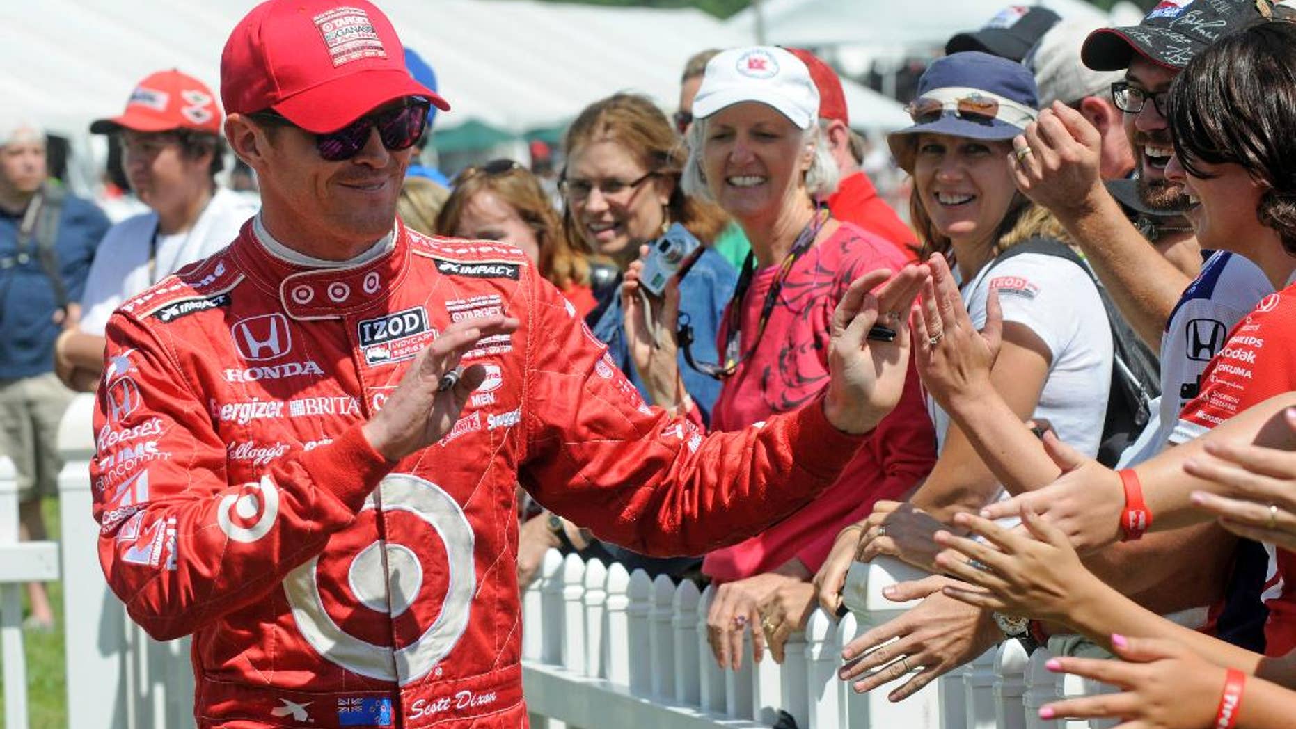 FILE - In this Aug. 4, 2013 file photo, Scott Dixon, of New Zealand, greets fans during driver introductions at the Honda Indy 200 at Mid-Ohio in Lexington, Ohio. Sponsors come and go in motor sports, where even the strongest partnerships can quickly unravel because of the economy, a difference of opinion or a change in marketing strategy. But Chip Ganassi has developed a partnership with Target that has lasted 25 years in counting, and the team owner considers the relationship with the retail giant a key element in the growth of his race team and Ganassi himself. (AP Photo/Tom E. Puskar, File)