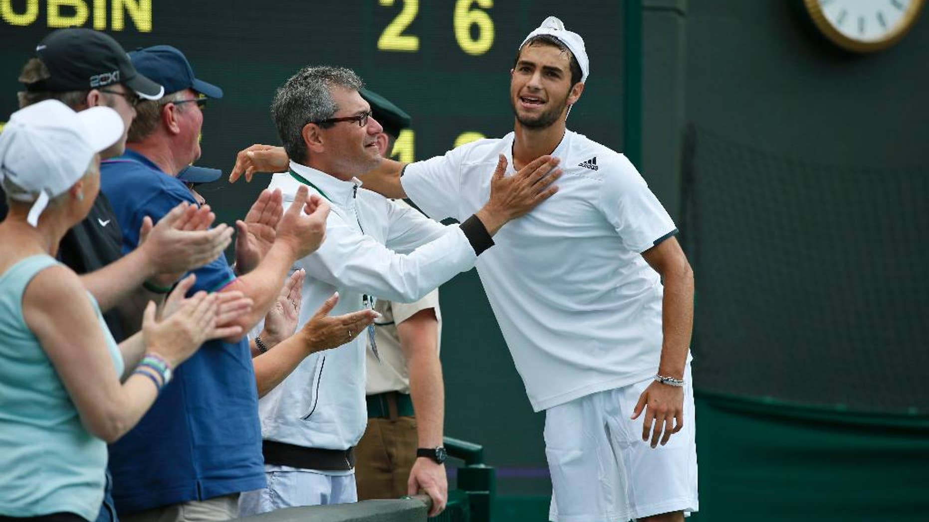 Noah Rubin of the U.S., right, is congratulated after defeating Stefan Kozlov of the U.S in the boys' singles final at the All England Lawn Tennis Championships in Wimbledon, London, Sunday July 6, 2014. (AP Photo/Alastair Grant)