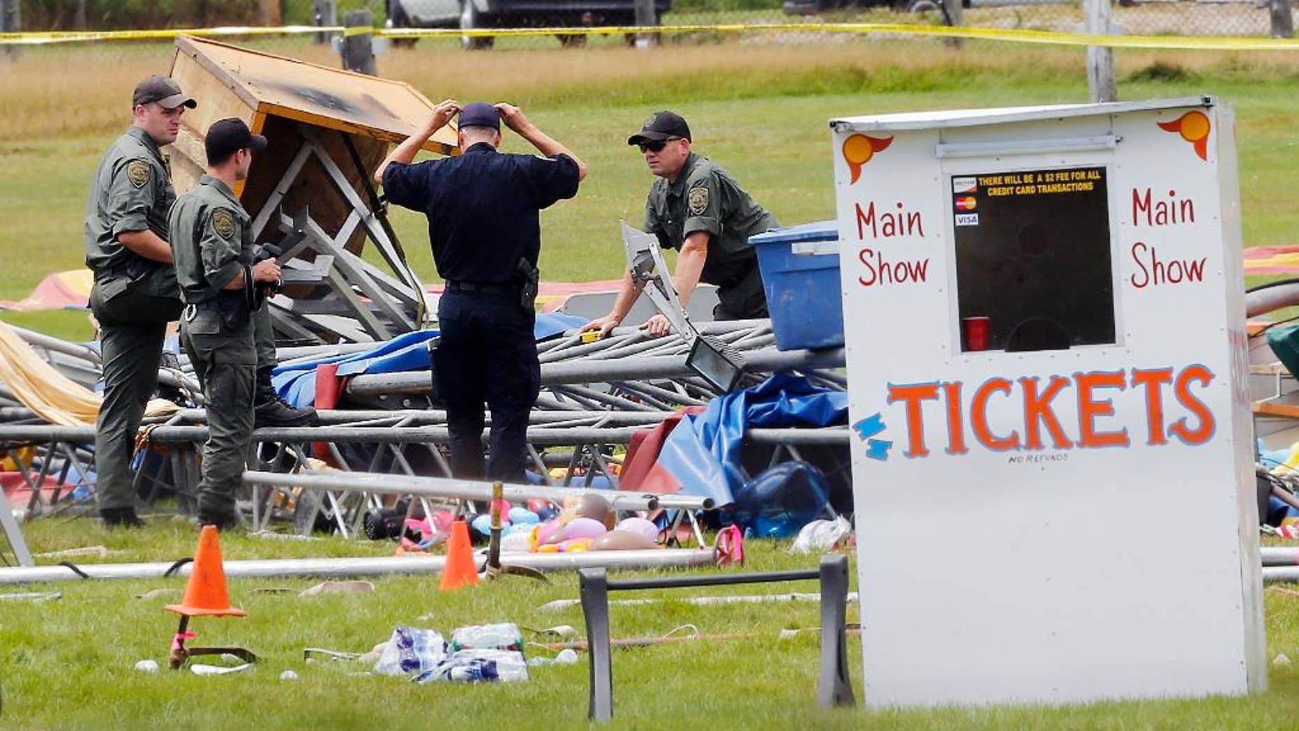 FILE - In this Aug. 4, 2015 file photo, investigators work at the scene of a circus tent that collapsed the previous day when a storm blew through, toppling it and killing a father and his 6-year-old daughter at the fairgrounds in Lancaster, N.H. In a plea agreement on Wednesday, May 3, 2017, a judge ordered the Florida-based circus operator to pay $15,000 in fines for operating without a license. (AP Photo/Jim Cole, File)