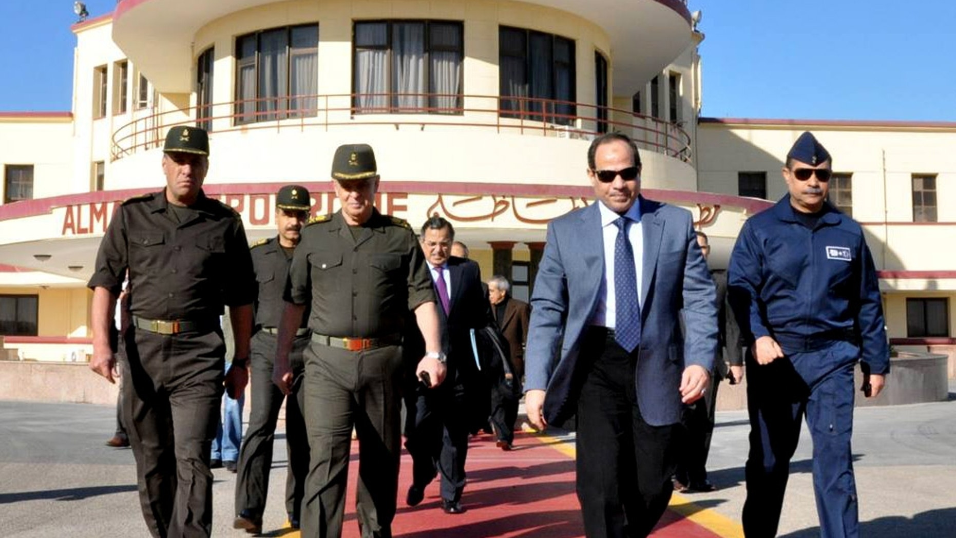 In this image released on the official Facebook page of the Egyptian Military Spokesman of the Armed Forces, Egyptian army chief Field Marshal Abdel-Fattah el-Sissi, second right, and Egypt's Foreign Minister Nabil Fahmy, center background, prepare to depart to Moscow from a military airport, in Cairo, Egypt, Wednesday, Feb. 12, 2014. El-Sissi headed to Moscow on Wednesday amid reports of a $2 billion arms deal in the making that would significantly expand Russia's military influence with a key U.S. ally in the Middle East. (AP Photo/The Official Facebook Page of the Egyptian Military Spokesman of the Armed Forces)