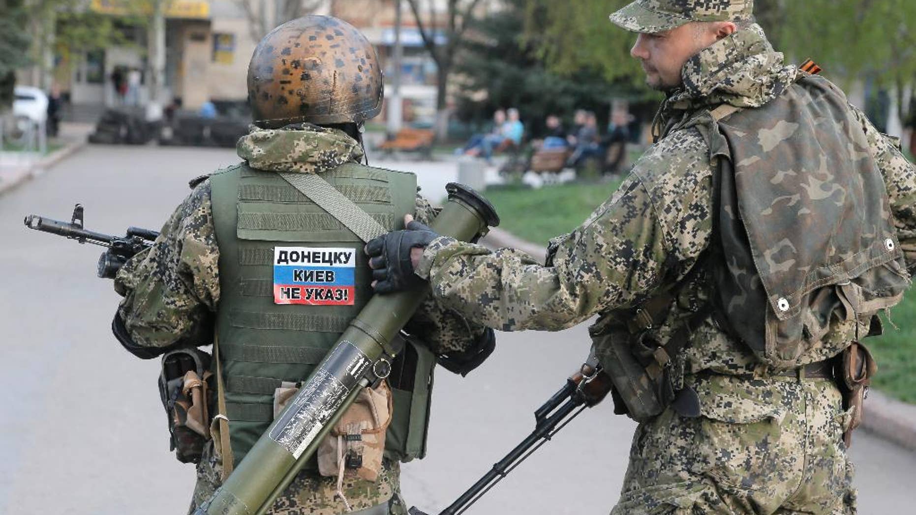 Pro-Russian gunman patrol a streets in downtown Slovyansk, Eastern Ukraine, Friday, April 18, 2014. Pro-Russian insurgents defiantly refused Friday to surrender their weapons or give up government buildings in eastern Ukraine, despite a diplomatic accord reached in Geneva and overtures from the government in Kiev. (AP Photo/Efrem Lukatsky)