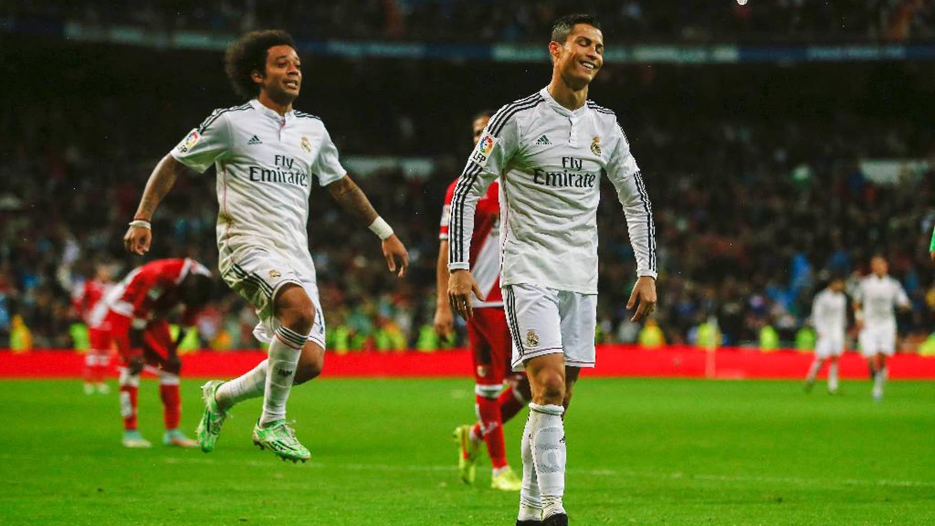 Real Madrid's Cristiano Ronaldo, center right, celebrates his goal with teammate Marcelo during a Spanish La Liga soccer match between Rayo Vallecano and Real Madrid at the Santiago Bernabeu stadium in Madrid, Spain, Saturday, Nov. 8, 2014. (AP Photo/Andres Kudacki)