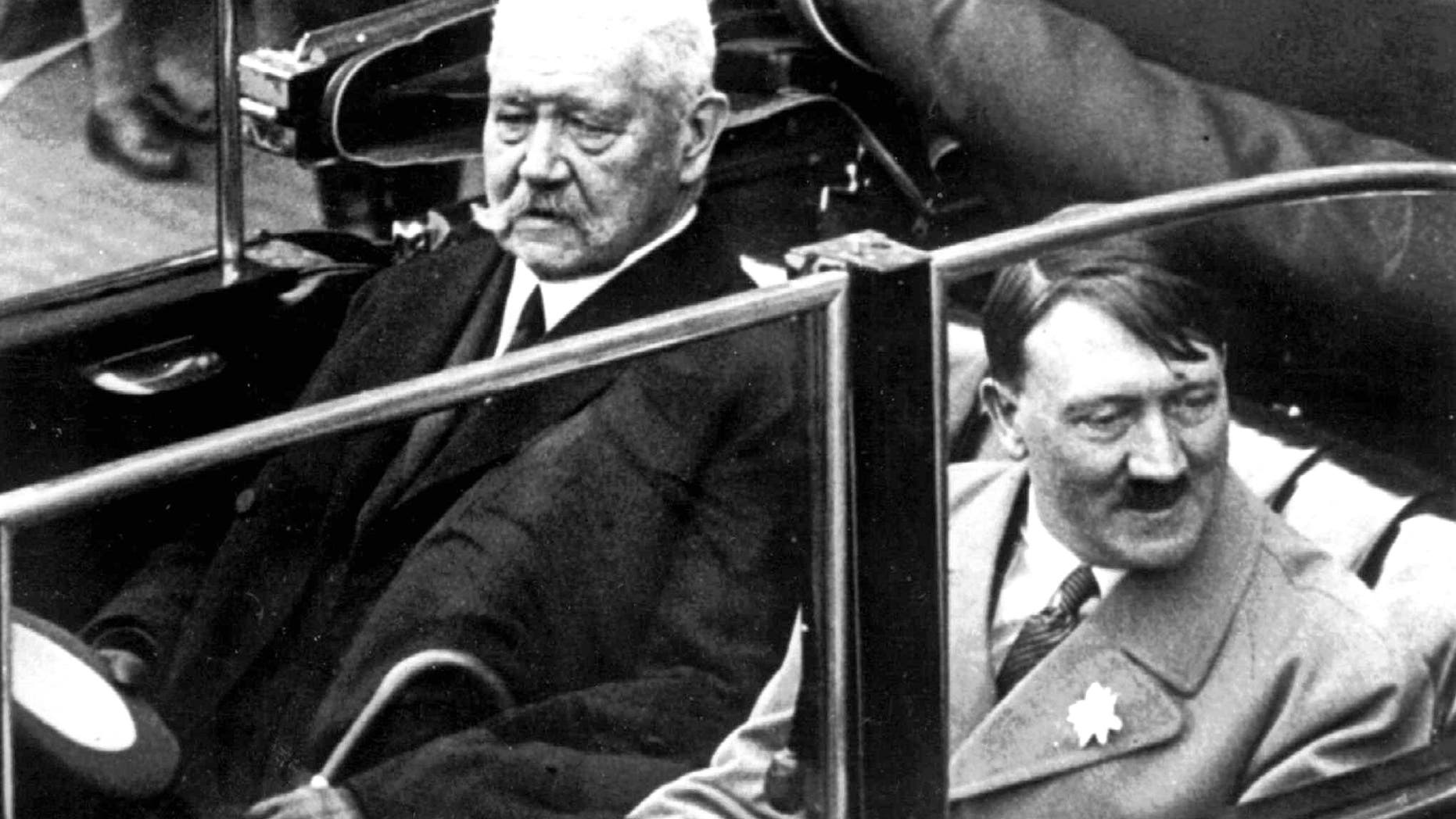 FILE May 1, 1933 file photo shows German President Paul von Hindenburg, left, and Adolf Hitler, right, in a car during a labor day celebration in Berlin. A Bavarian town has voted to strip Adolf Hitler of honorary citizenship bestowed upon him 80-years ago after an outcry prompted by their decision last week not to adopt a resolution denouncing the 1933 decision. The issue came up after an archivist discovered documents showing both Hitler and the president who appointed him, Paul von Hindenburg, had been given honorary citizenship of Dietramszell. A partial town council deadlocked in an 8-8 vote last week on the resolution, with councilors voting against saying it was not up to them to rewrite history. But town administrator Thomas Gerg said Wednesday Dec. 18, 2013 the full council voted Tuesday 21-0 both to adopt the resolution and nullify the citizenship for both men after hearing impassioned testimony from a woman who lost family in the Holocaust. (AP Photo)