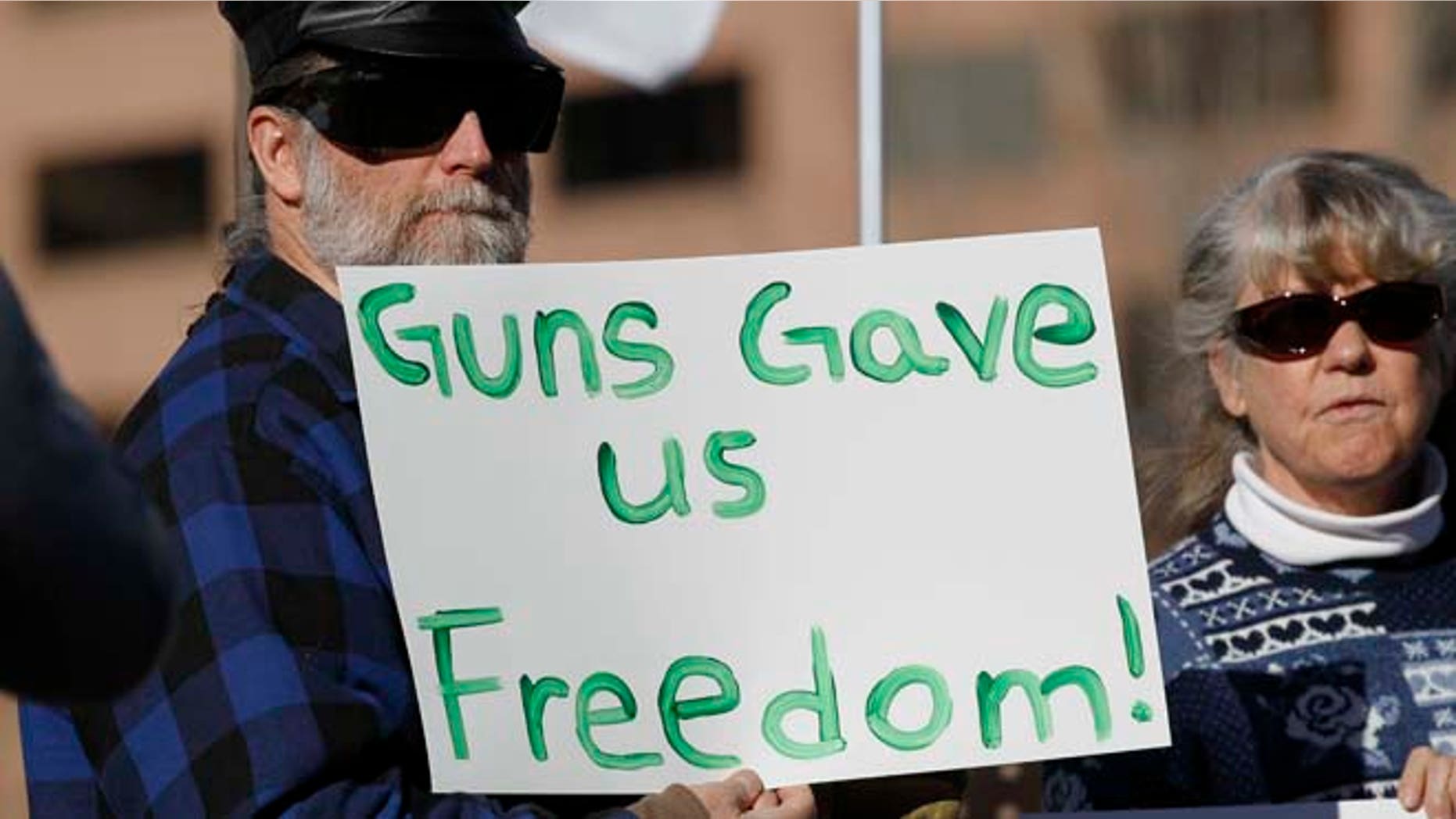 Jan. 9, 2013: Daniel White of Estes Park, Colo., waves a placard at a pro-gun rally as the Colorado Legislature opened its general session across the street in the State Capitol in Denver.