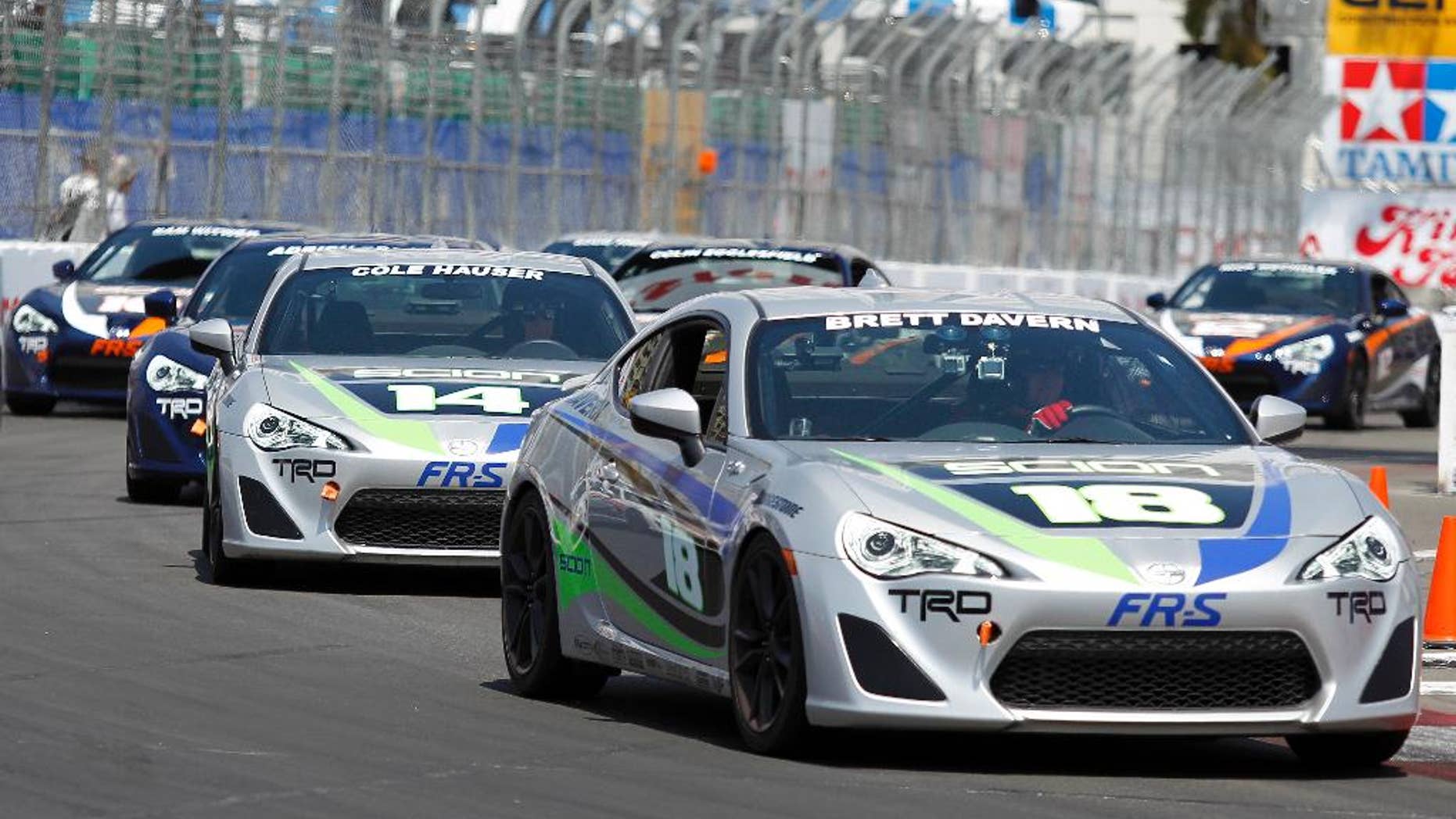 Brett Davern (18) leads Cole Hauser (14) and the rest of the pack in the Pro/Celebrity Grand Prix of Long Beach auto race on Saturday, April 12, 2014, in Long Beach, Calif. Davern won the race. (AP Photo/Alex Gallardo)