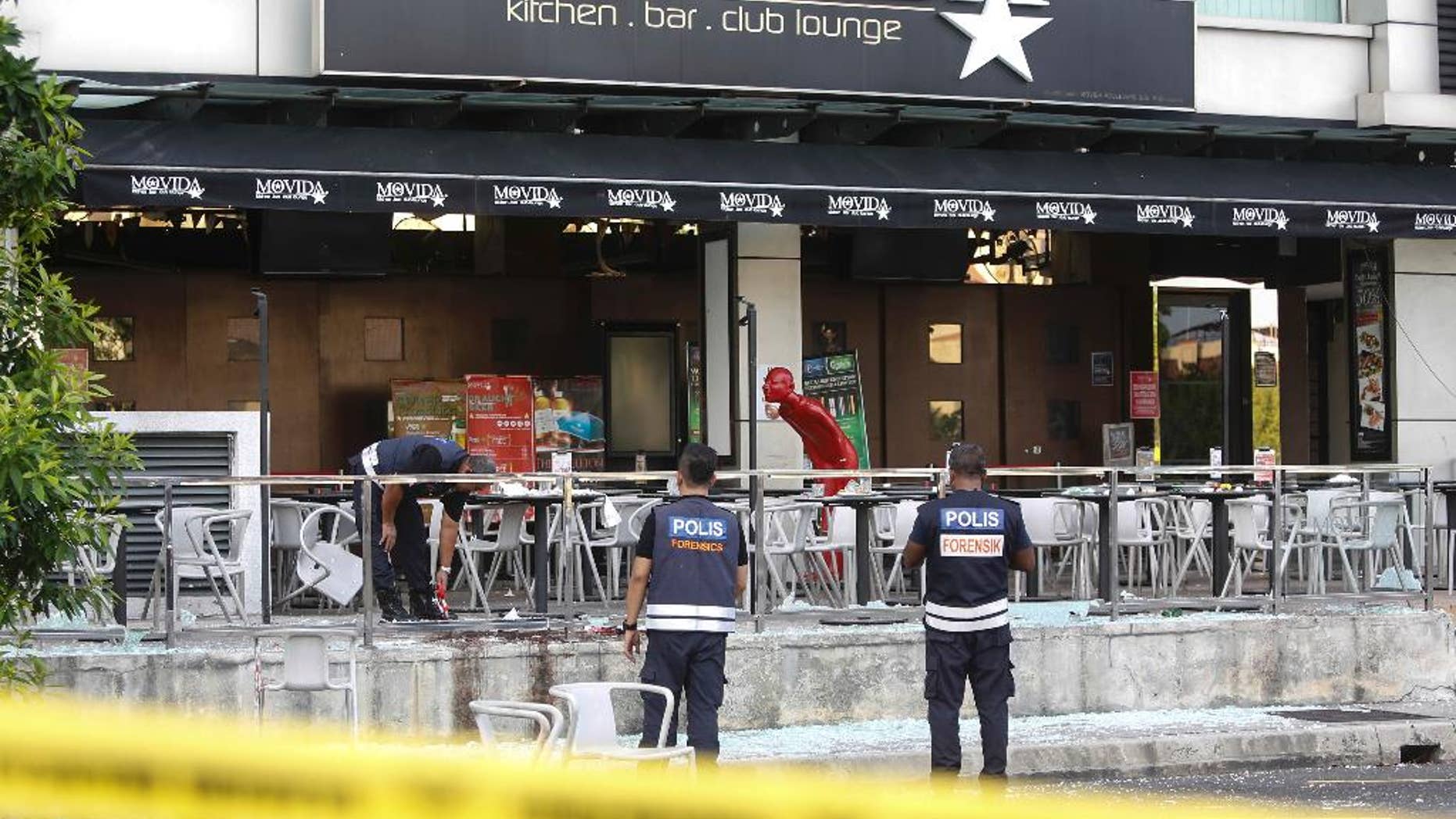 FILE - In this June 28, 2016, file photo, Malaysian forensic personnel inspect the blast site of a grenade attack at a bar and restaurant in Puchong, outside Kuala Lumpur, Malaysia. Malaysia's police chief said Monday, May 8, 2017, the country's top Islamic State operative was killed in an attack in Syria last month. Muhammad Wanndy Mohamed Jedi, 26, was believed to have been responsible for the grenade blast that injured eight people. It was the first attack in the country by the Islamic State militant group. (AP Photo/Joshua Paul, File)