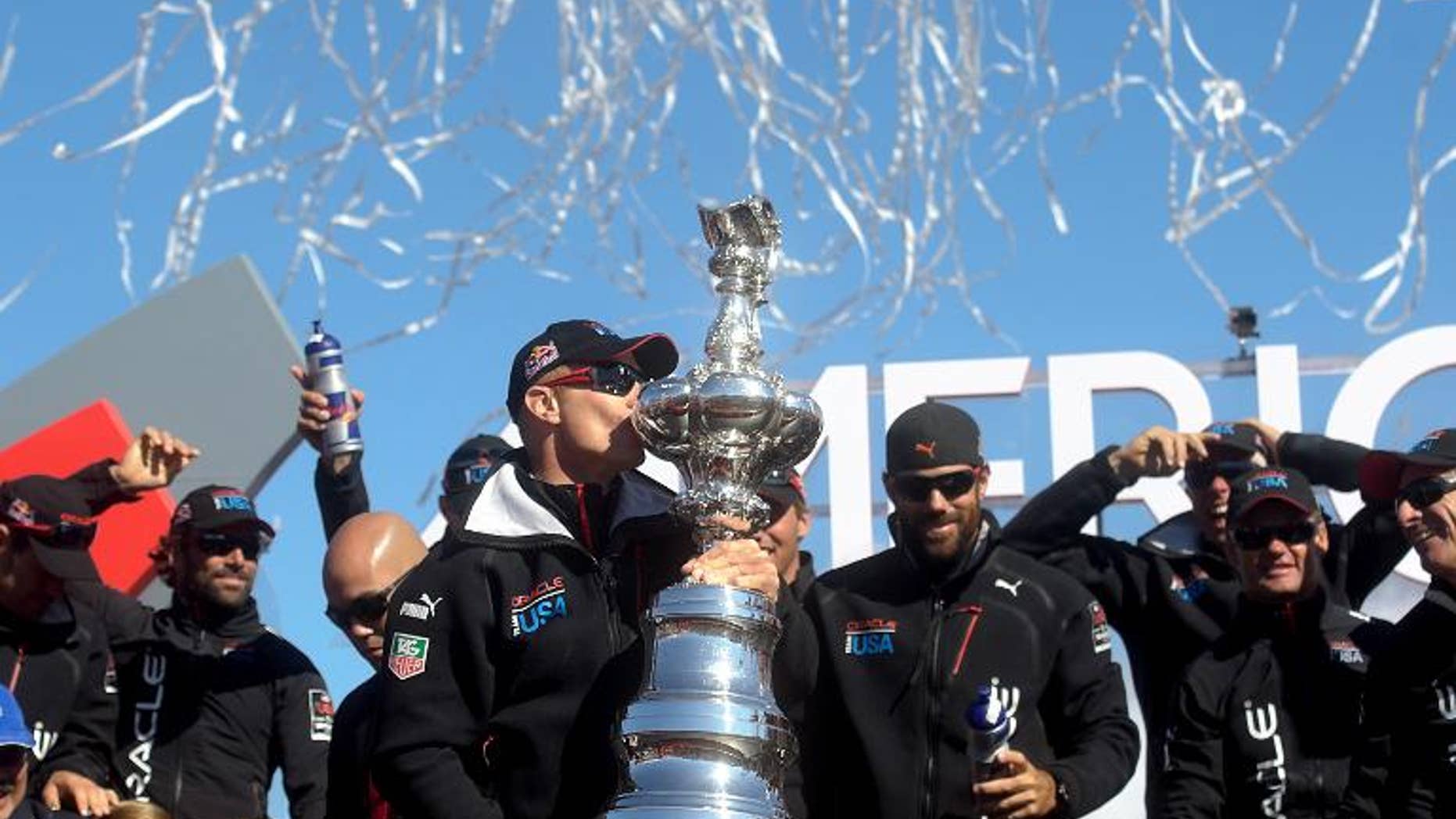 Oracle Team USA skipper Jimmy Spithill kisses the America's Cup trophy while celebrating his team's victory over Emirates Team New Zealand in the 34th America's Cup on September 25, 2013, in San Francisco