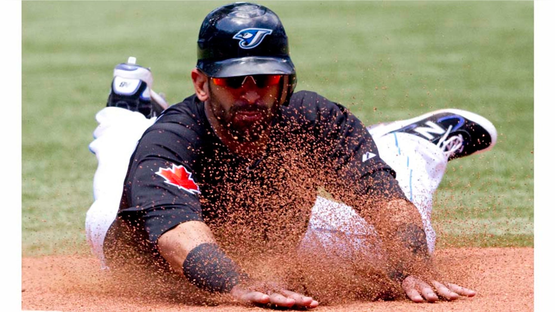 Toronto Blue Jays' Jose Bautista slides safely into third base during sixth inning of a baseball game against the Philadelphia Phillies, Sunday, July 3, 2011, in Toronto. The Blue Jays defeated the Phillies 7-4. (AP Photo/The Canadian Press, Darren Calabrese)