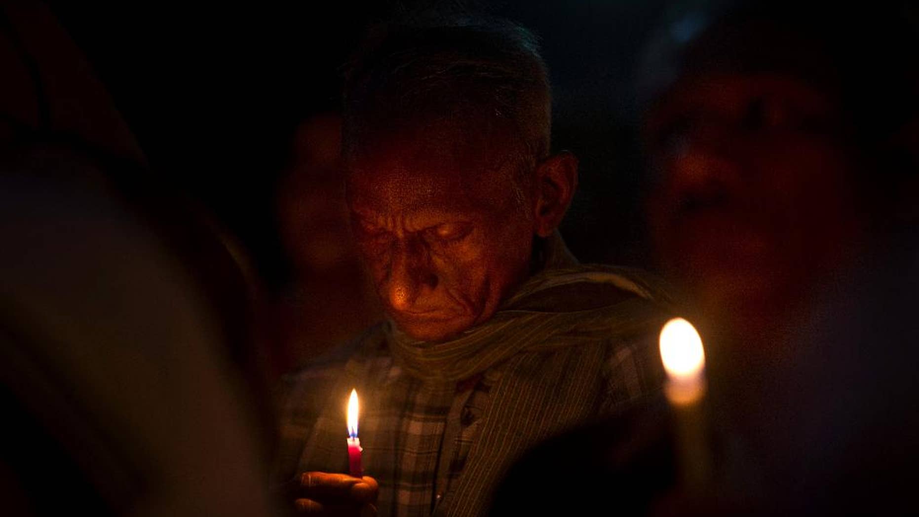An Indian man prays as Christians and others hold a candle light vigil to condemn the gang rape of a nun at a Christian missionary school in eastern India outside the Sacred Heart cathedral in New Delhi, India, Monday, March 16, 2015. According to police a nun in her 70s was gang-raped by a group of bandits when she tried to prevent them from committing a robbery in the Convent of Jesus and Mary School in West Bengal state's Nadia district. The attack early Saturday is the latest crime to focus attention on the scourge of sexual violence in India. (AP Photo/Saurabh Das)