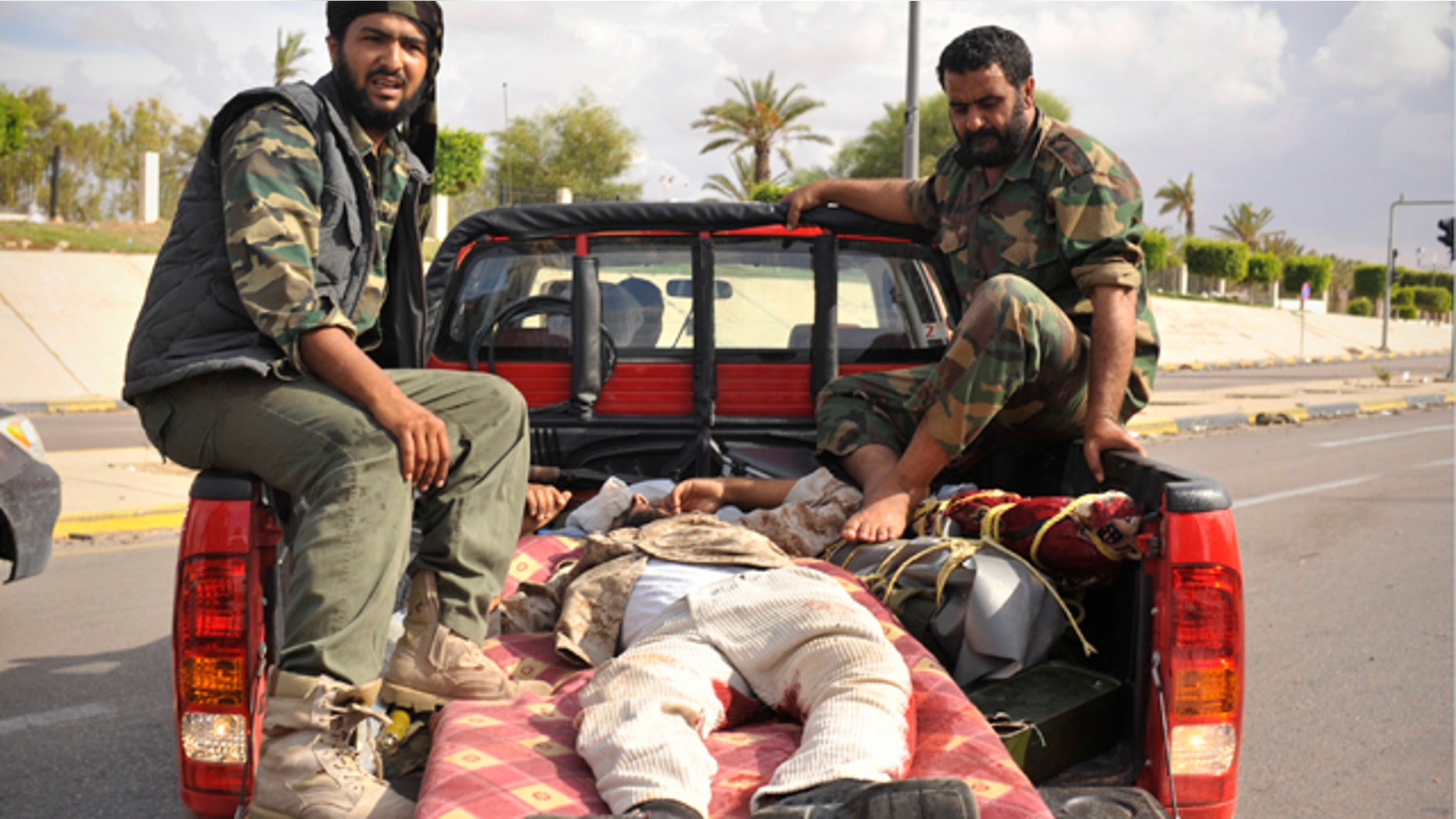 Oct. 13: Libyan revolutionary fighters transport their injured comrade in Sirte, Libya.