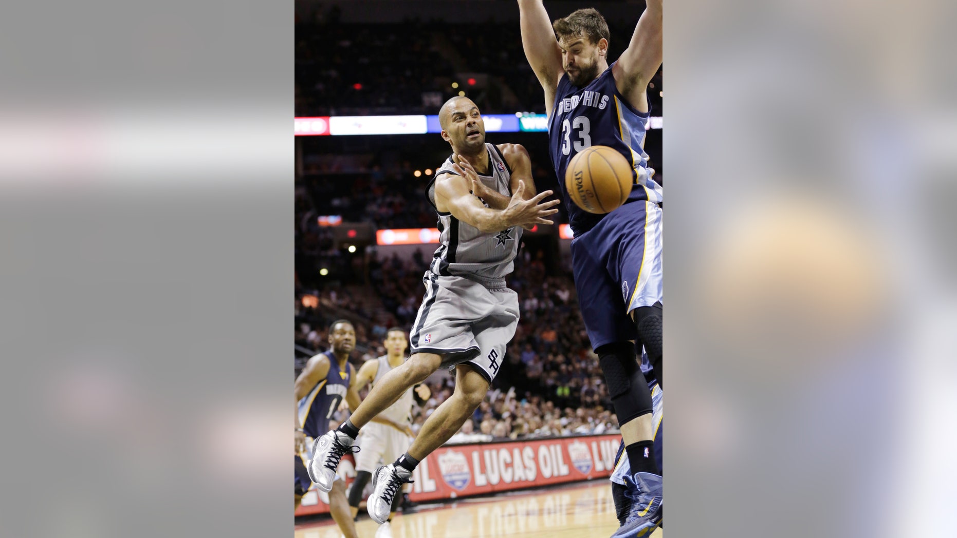 San Antonio Spurs' Tony Parker (9), of France, passes the ball around Memphis Grizzlies' Marc Gasol (33), of Spain, during the second half on an NBA basketball game, Wednesday, Oct. 30, 2013, in San Antonio. (AP Photo/Eric Gay)