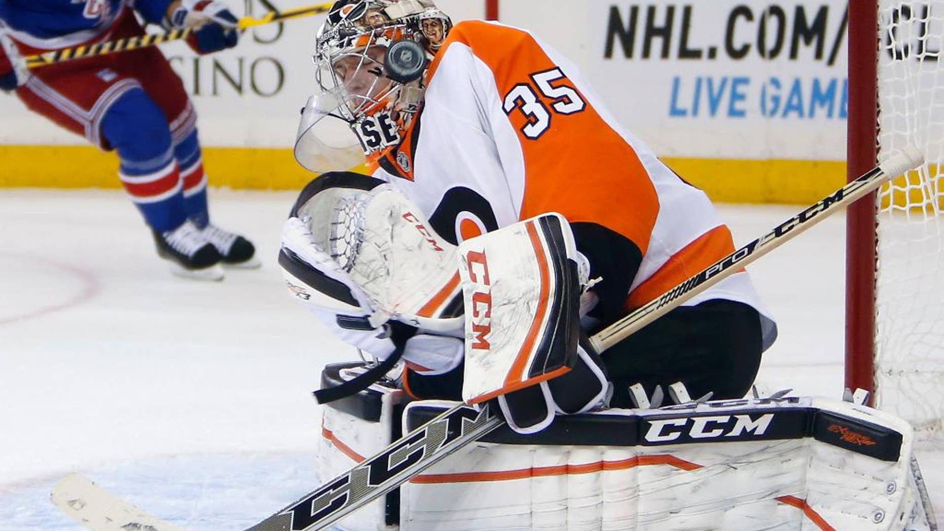 Philadelphia Flyers goalie Steve Mason (35) deflects a shot during the second period of an NHL preseason hockey game against the New York Rangers, Monday, Sept. 29, 2014, in New York. (AP Photo/Jason DeCrow)