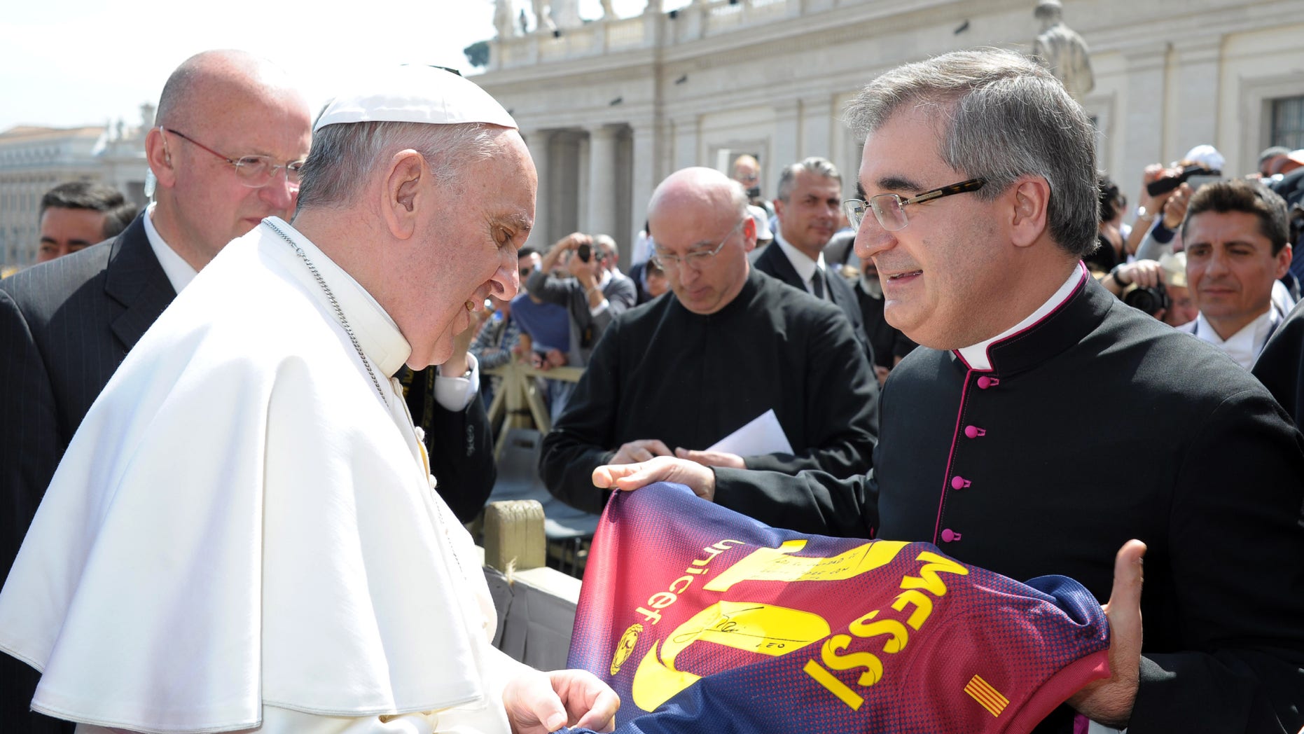 In this photo provided by the Vatican paper L'Osservatore Romano and made available Thursday, April 18, 2013, Mons. Miguel Delgado Galindo presents a jersey of Argentine soccer star Lionel Messi to Pope Francis, at the Vatican Wednesday, April 17, 2013. (AP Photo/L'Osservatore Romano, ho)