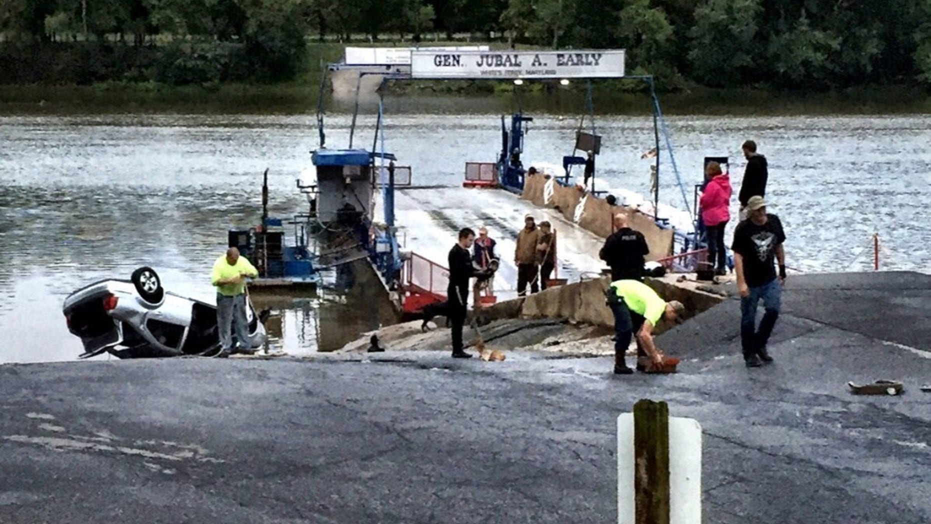 Emergency personnel respond to White's Ferry in Dickerson, Md., after what authorities say a man driving under the influence, drove his car off a ferry into the Potomac River. The driver was rescued, then charged with DUI. (Neal Augenstein/WTOP via AP)