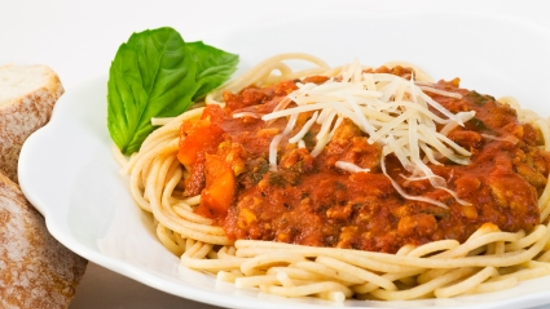 Bowl of whole wheat spaghetti and sauce. The sauce includes ground turkey, fresh basil, tomato sauce, bell peppers, onions, mushrooms, garlic, olive oil and italian seasonings.
