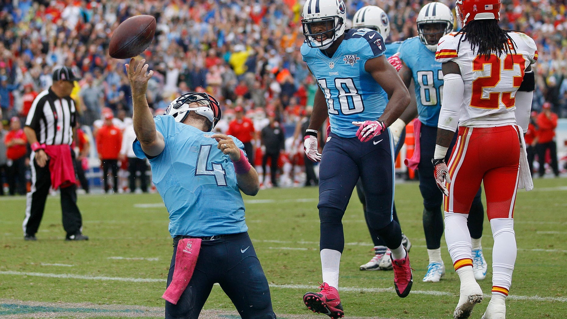 Tennessee Titans quarterback Ryan Fitzpatrick (4) celebrates after scoring a touchdown on a 9-yard run against the Kansas City Chiefs in the fourth quarter of an NFL football game on Sunday, Oct. 6, 2013, in Nashville, Tenn. Titans wide receiver Kenny Britt (18) runs up to Fitzpatrick as Chiefs safety Kendrick Lewis (23) walks away. (AP Photo/Wade Payne)