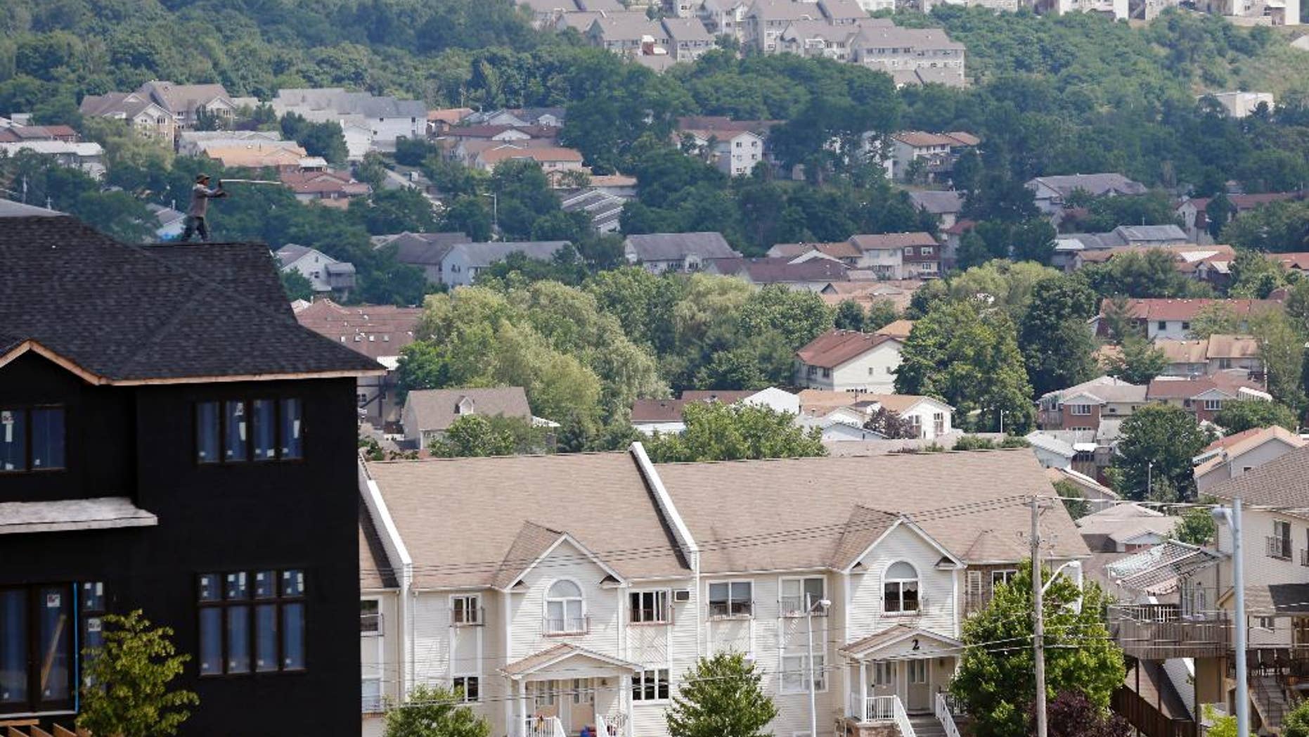 FILE - In this July 1, 2014, file photo, a new housing unit, left, is under construction in Kiryas Joel, N.Y. Agents with the FBI and other law enforcement agencies have seized documents from the Hasidic village on May 12, 2016, as part of an ongoing investigation. (AP Photo/Mike Groll, File)